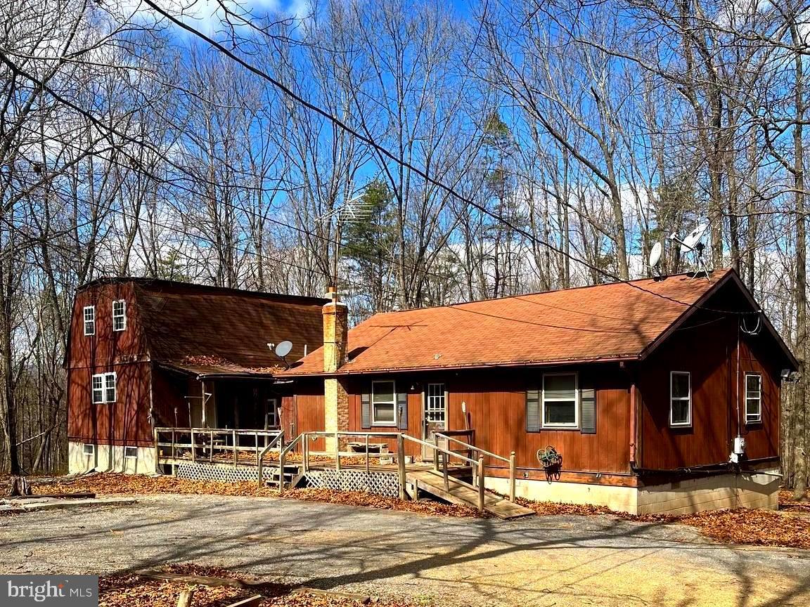 Check out the UNLIMITED POSSIBILITIES!!  with this home nestled on 8+-acres.  Home has 3-4 Bedrooms and 2.5 Baths.  The loft bedroom adds charm and has a full bath. The two storage buildings convey with the property. This home is in need of work. Make this beautiful setting a place to create your next dream home. The house is being sold As-Is. Current Covenants prohibit commercial use of the property.