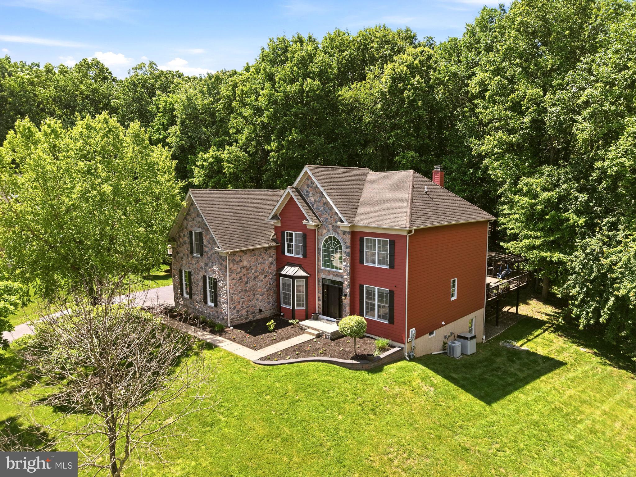 Welcome to 1344 Brownsville Road in the highly sought-after Chestnut Ridge Estates and award-winning Downingtown Area School District. Tucked away at the end of a quiet cul-de-sac, this exceptional home offers a rare combination of privacy, luxury, and modern updates, all set against breathtaking wooded views that create a peaceful retreat right in your own backyard. Step through the soaring two-story foyer and immediately appreciate the warm hardwood flooring that spans the entire first floor, complemented by a fresh neutral color palette and thoughtfully updated finishes throughout. Designed for both everyday living and entertaining, the home features an open and flowing floor plan centered around an impressive two-story family room with a dramatic floor-to-ceiling fieldstone fireplace, a wall of windows, and stunning views of the surrounding landscape. A custom accent wall adds a modern designer touch, creating a space that feels both grand and inviting. The spacious kitchen is the heart of the home, offering abundant cabinetry, expansive countertops, stainless steel appliances, a center island, and a bright breakfast area surrounded by windows and skylights. Just beyond, a cozy sitting area with a second fireplace creates the perfect gathering space. For larger celebrations, the formal dining room provides ample room for hosting family and friends. A private first-floor office with direct access to the outdoor living space, a well-appointed powder room, and a functional laundry/mudroom with access to the three-car garage complete the main level.  A unique secondary staircase off the kitchen, complete with a chair lift, provides convenient access to the second floor. Upstairs, the luxurious primary suite enjoys its own private wing of the home, featuring a spacious sitting area, a spa-inspired ensuite bath with dual vanities, soaking tub, and separate shower, as well as an enormous walk-in closet. The second bedroom boasts its own beautifully updated ensuite bath and walk-in closet, while the remaining bedrooms are generously sized and served by an additional full bath. The recently finished lower level significantly expands the living space and offers endless possibilities. Featuring a massive recreation room, custom wet bar, full bathroom, dedicated bonus room ideal for a gym, guest suite, office, or hobby space, plus substantial unfinished storage areas, this level has been thoughtfully designed for both entertaining and functionality.  Outside, discover what truly sets this property apart. The spectacular outdoor oasis features approximately 2,400 square feet of decking and stone patio space, complete with professional landscaping, accent lighting, built-in sound, and multiple areas to relax or entertain. Guests are welcomed through a handcrafted arbor into a picturesque gathering space centered around a stone fire pit. The expansive deck overlooks the serene wooded backdrop, while a custom-built stage provides a unique venue for outdoor performances, celebrations, or simply enjoying the beauty of nature.  Residents of Chestnut Ridge Estates also enjoy access to private walking trails and a community park/playground, all while being just minutes from Downingtown Borough, regional rail, major commuting routes, dining, shopping, and parks. A truly one-of-a-kind property where modern updates, exceptional indoor living spaces, and unforgettable outdoor entertaining come together to create the perfect place to call home.