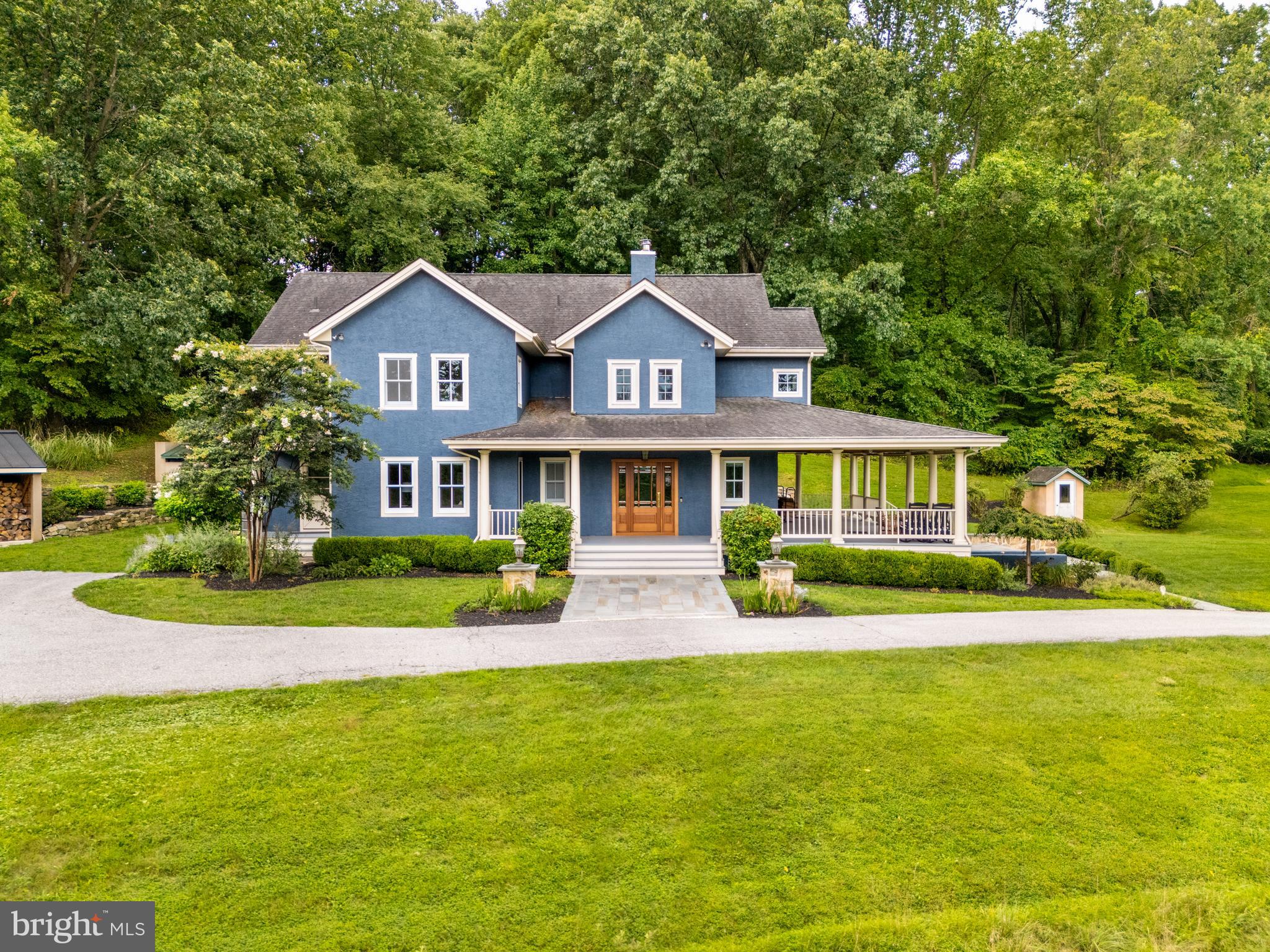 Looking for something extraordinary?  Don't miss this exceptional custom-built farmhouse-style home nestled in Charlestown's Historic District. Situated on 10.4 acres, this hilltop retreat framed by natural stone lighted columns, offers a serene setting accessed by a winding, steep driveway. The distinctive residence boasts 4,071 square feet of flexible living space. Step through the custom Mahogany front door into the natural stone-floored foyer, leading into the 2-story great room through elegant French doors. Here, hardwood floors, custom windows, and unique ceiling fixtures create an inviting atmosphere. A highlight is the Tulikivi wood stove with a soapstone hearth, renowned for its ability to retain and release heat gradually as radiant warmth, ensuring warmth & comfort in the colder weather. The adjacent kitchen features  a dry bar, stainless steel appliances, white cabinetry, slate countertops, and a breakfast bar. For outdoor entertaining, a blue slate patio with a bread/pizza oven and granite countertop awaits just outside. The main level includes ample storage, a home office with built-in bookshelves, a full bathroom, a beautifully appointed laundry room, and a spacious mudroom with side entry. Upstairs, a cozy reading nook leads to two generously sized bedrooms sharing a full bath, while the primary bedroom offers dual walk-in closets and an updated en-suite bathroom with double vanity and a step-in shower. The third level features a fourth bedroom with its own new full bathroom and access to abundant attic storage. The lower level adds 297 square feet of finished space suitable for a game or exercise  room or an additional office, complemented by a 532 square foot workshop with an outside entrance and extra storage space. Outdoor enthusiasts will appreciate the expansive covered wrap-around porches, providing panoramic views and overlooking the vegetable gardening area. A blue stone patio with a natural stone firepit extends the outdoor living space, accompanied by ample vehicle parking and an open storage shed at the rear. Conveniently located near Charlestown Elementary School, the Great Valley High and Middle School campus, Great Valley Corporate Center, Wegmans, Route 202, and the Turnpike slip ramp, this home also benefits from a whole house generator and low taxes thanks to Act 319 registration. Schedule an appointment today to visit this remarkable property and experience its peaceful setting and abundant amenities firsthand.