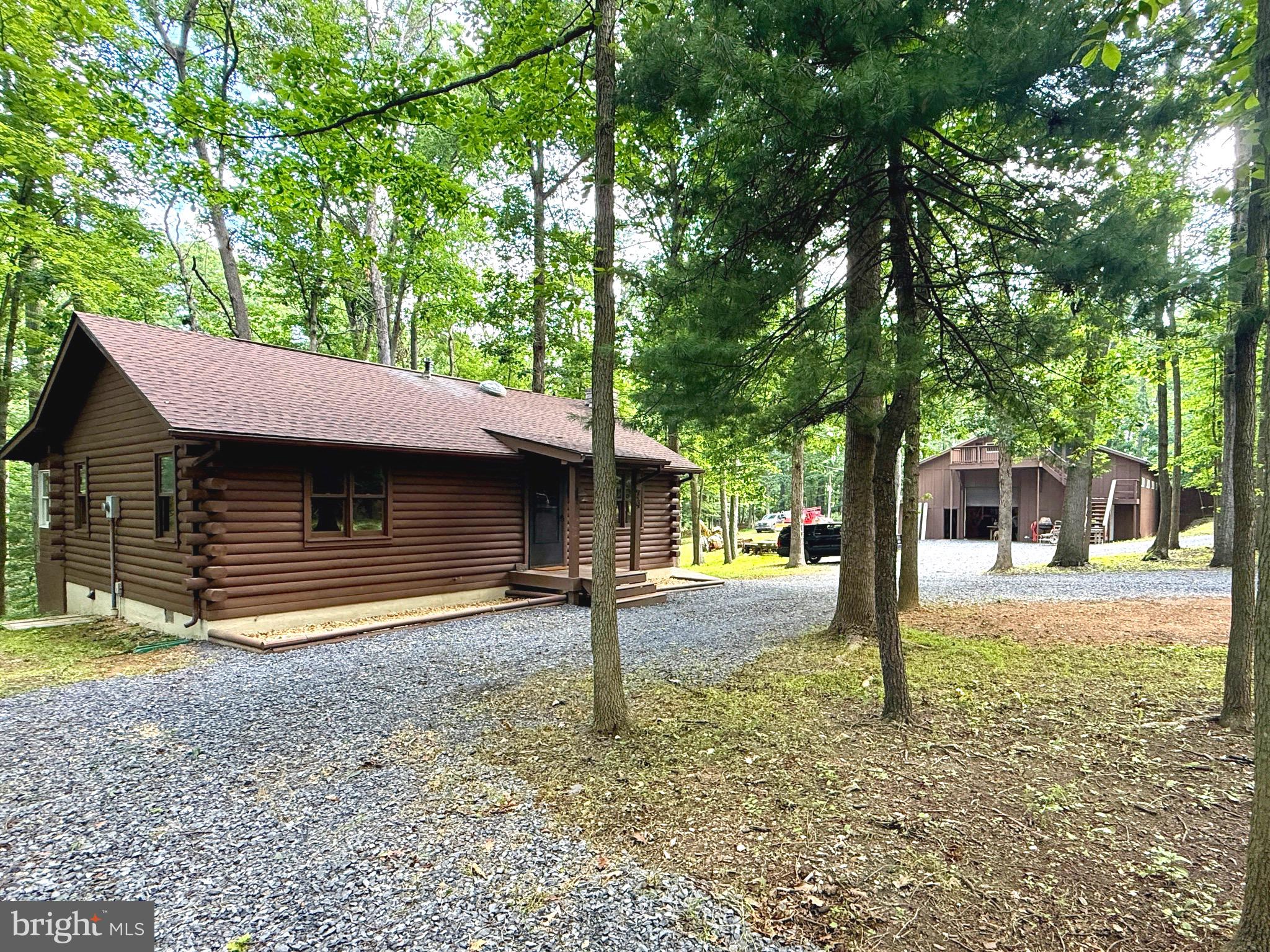 Extensively Remodeled Log Cabin on 2.59 Wooded Acres with Oversized Garage & Workshop! Welcome to this beautifully renovated 3-bedroom, 2-bath log cabin, where rustic charm meets modern convenience. Nestled on 2.59 private wooded acres, this move-in-ready property has been extensively remodeled from top to bottom, allowing you to simply unpack and enjoy. Step inside to a warm and inviting open-concept living area featuring stunning log interior walls, soaring character, and a gorgeous stone wood-burning fireplace with a rustic mantel as the centerpiece. The spacious kitchen has been completely updated with brand-new cabinetry, elegant granite countertops, a Frigidaire stainless steel appliance package, and modern lighting. Throughout the home you'll find new luxury vinyl plank and luxury vinyl tile flooring, new carpet, updated lighting, new ceiling fans, new electric baseboard heating, a beautifully remodeled bathrooms with new vanities and toilets, and countless additional improvements. A new roof and new decking add even more value and peace of mind. Outside, the possibilities continue with an oversized detached garage offering exceptional flexibility. The garage features abundant loft storage, an office with both private exterior and interior access, and a separate finished space above with its own exterior entrance. Additional outbuildings include a woodshed and a workshop shed, providing even more room for storage, hobbies, or equipment. Whether you're looking for a full-time residence, mountain getaway, or investment opportunity, this unique property offers an incredible amount of functional space both inside and out. This is more than just a home—it's a lifestyle. Schedule your private showing today and experience everything this exceptional property has to offer.