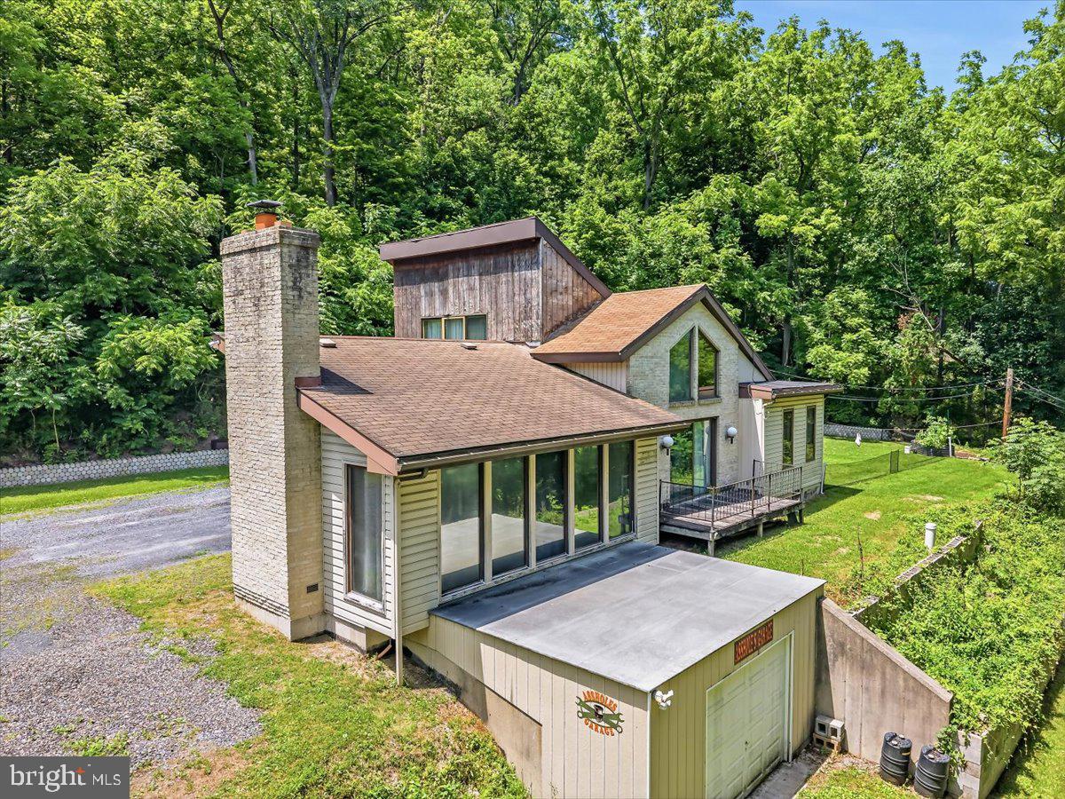 Privately positioned on multiple parcels in Whitehall Township, 5340 2nd Street offers a rare blend of seclusion, usable land, garage space, and everyday convenience. Set back from the road and surrounded by mature trees, this 2-bedroom, 1-bath ranch-style home delivers approximately 1,490 square feet of estimated finished living space with a flexible layout designed for buyers who value privacy, storage, and room to personalize over time.. The main level features an open dining area, updated kitchen with stainless steel appliances, a bright living room, two bedrooms, first-floor laundry, and access to outdoor living space. The oversized rear bedroom offers excellent flexibility, while the upper loft creates additional bonus space for an office, media room, reading lounge, or studio. The full walk-out basement expands the utility of the home with space for storage, workshop use, recreation, or future finished potential. A two-car garage, generous driveway parking, wooded surroundings, covered outdoor space, and seller-reported Culligan water filtration/softening system add to the property’s appeal. With additional parcel land included in the sale, this property offers privacy, flexibility, and a setting that feels tucked away while remaining convenient to Whitehall, major routes, shopping, schools, and the Lehigh Valley.