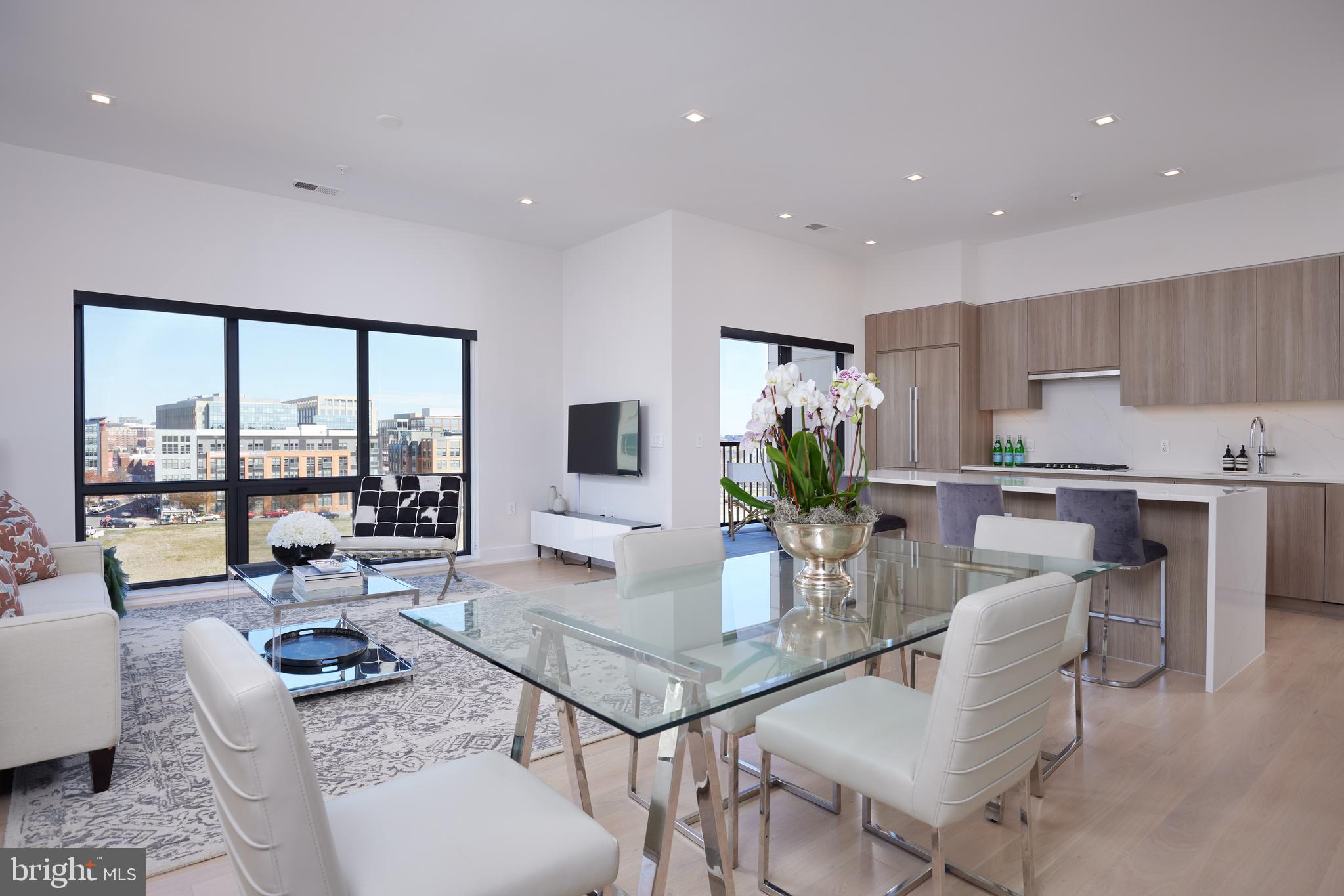 Live luxuriously and at a LOWER INTEREST RATE! Sellers are offering a closing credit towards buyer interest rate buydown with an accepted offer! * 

PENTHOUSE living at its finest: this nearly new, meticulous and move-in-ready top floor two bedroom + den (or third bedroom), two full, and one half bath condominium is ready for its lucky new owners. 

Relax and enjoy or entertain in style as the terrific floor plan boasts a dramatic entry foyer and gallery hall, luxuriously-scaled living and dining areas smartly situated around a chic and sleekly appointed kitchen with full custom cabinetry, polished quartz counters, and a sensationally-scaled center island. These dramatic rooms are all punctuated with floor to ceiling windows, soaring ceilings, and fantastic views of the Potomac River, the Capitol dome, and airplanes taking off and landing at National Airport. The sense of volume, light, and air is simply magical throughout and is further enhanced by a private outdoor space accessed directly off of the kitchen.

The incredible primary suite delivers in droves, too. Grand enough to easily accommodate a king-sized bed and furnishings, yet intimate and serene in feel, this quiet oasis offers a fabulous en-suite bathroom plus divine, dual walk-in closets each outfitted by the acclaimed firm, Capitol Closets. Perfectly positioned, the second bedroom is bright and spacious and is wonderfully appointed with its own en-suite bathroom and terrific walk-in closet. A discreet powder room is located just off of the foyer while the sizable and flexible den/third bedroom sits quietly off the main living area.

The Dylan is a refined and elegant address and boasts a lovely array of amenities that include secure entry, concierge, parking garage (2 private spaces convey with the sale of #604), extra storage (1 private locker coveys with the sale of #604), business center, art/project room, fantastic party room, and large common outdoor terrace with grill and lounging areas. The location is absolutely stellar with ease of access to DC, Old Town and beyond, Potomac Yards/VT Metro stop (Blue and Yellow lines and an approximate 7 minute walk from the building), green spaces galore, plentiful restaurants and shopping choices. A rarely available penthouse in absolutely top condition and in a top location. Sounds like the perfect time to move on up!

*