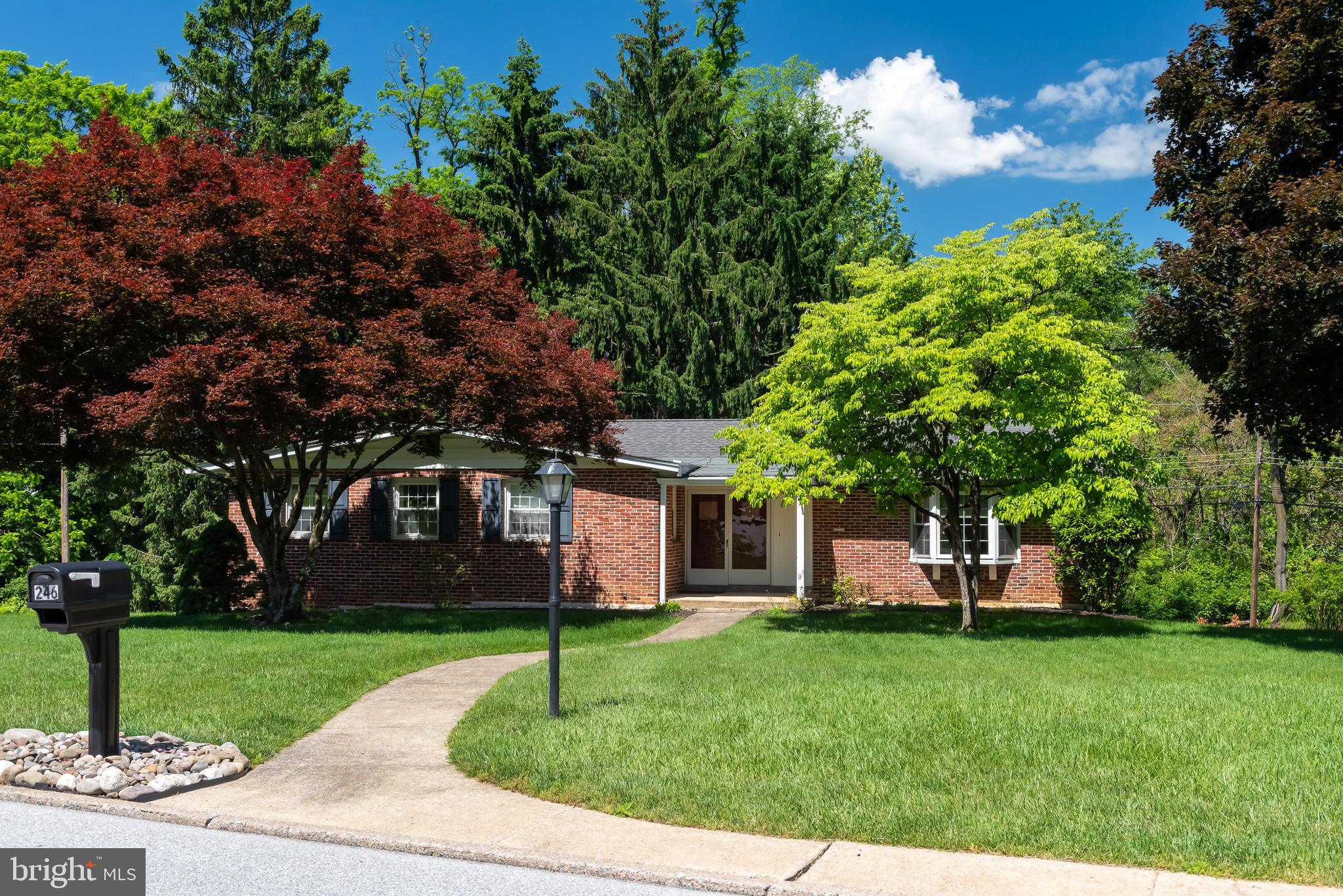 Welcome to 246 Friendship Drive, a wonderful, solidly built home with a finished walkout basement in the heart of Paoli, located within the award-winning Tredyffrin/Easttown School District. This well-maintained home offers an excellent opportunity to own in the centrally located neighborhood of Friendship Hills. A charming covered front porch leads into a tiled entry hall. The heart of the home is the eat-in kitchen featuring generous cabinet and counter space, quartz countertops, subway tile backsplash, and a stainless steel sink. The open-concept living and dining areas offer great views through picture windows. Hardwood flooring extends down the hallway to the bedroom wing. The owner’s suite offers a private tiled bathroom and two walk-in closets. Two additional bedrooms each feature excellent closet space and are serviced by an updated hall bathroom with beautiful tile work and a tub/shower combination. The finished walkout lower level provides outstanding flexible living space with a wood-burning fireplace featuring a stone surround and raised hearth, along with sliding glass doors leading to the rear patio and backyard. A mudroom area connects to the oversized two-car garage and includes an adjacent powder room. The large workshop/storage/utility room is an exceptional bonus space with a built-in workbench, washer and dryer hookups, shelving, closets, and an exterior door to the rear of the property.  This bright and airy home is just steps from Friendship Park and a short distance to Wilson Farm Park and Valley Forge National Historical Park. A wonderful opportunity to own a solidly built home in a fantastic location, close to the shops, trains, and restaurants of the Main Line. This is the one you’ve been waiting for. Welcome home!