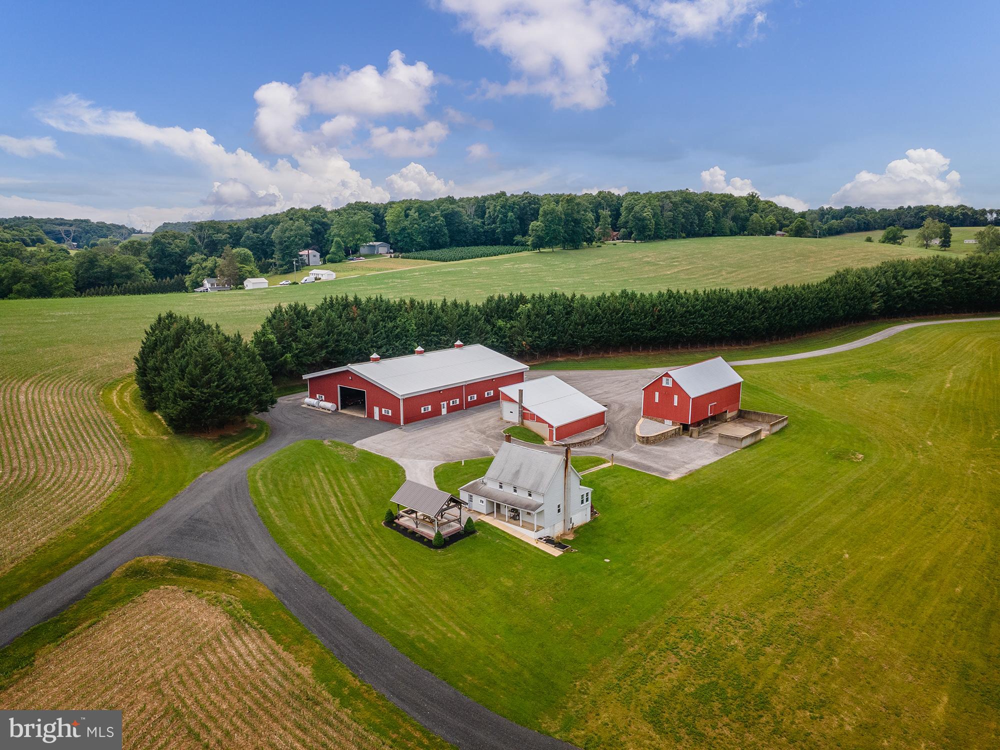 176 acres of wonderfully maintained, improved, and functional pastoral farmland awaits you in Baltimore County! With 100 tillable acres, a fully operational business layout, and wooded acreage full of wonderful trails, streams, hunting and recreational opportunities, the private views are as endless as the options this property offers for business owners, farmers, outdoor enthusiasts, multigenerational property owners, and homesteaders alike. The property is in Agricultural Preservation, and backs up to the coveted Rail Trail for endless miles of riding, hiking, or biking! There are two residences on the property (separate parcels and deeds) - the original farm house with 4BR and 2BA, and the ranch home, which is a 3BR 1BA with central air. The outbuildings are upgraded in size, amenities, and features, and are the perfect place to run a business out of or for amazing storage potential. The main shop is 81x110 and is insulated and heated with plumbing, a bathroom and finished office space. The floor is an 8 inch slab with drainage, and there are 3 24x15 bay doors (one on each side), 4 man doors, and 200 amp electric service. The back shop is 60x160 with 3 30x16 slider doors, 3 man doors, a 6 inch slab on 6,000 sf and the rest millings. This shop is generator-ready and wired. There are also several other outbuildings including a bank barn, additional 2-story bank-style shop, storage shed and graded area originally completed to be a shooting range, and a 12x24 pavilion with Gazebo behind the farm house. A creek runs through the property and there are multiple graded, maintained private lanes for ease of access and traversing the grounds. Not a soul in sight, and completely private, the setting of 901 Freeland Rd is incomparable. Farming, agritourism, machine work, equestrian or livestock facility - 901 Freeland Rd has the space, the potential, the infrastructure, the endless opportunity for ride-out, the mix of field, forest, water elements, residences, and outbuildings to make truly any dream you have come true - see your plans take shape the moment you meander down the private lane into your rural paradise.