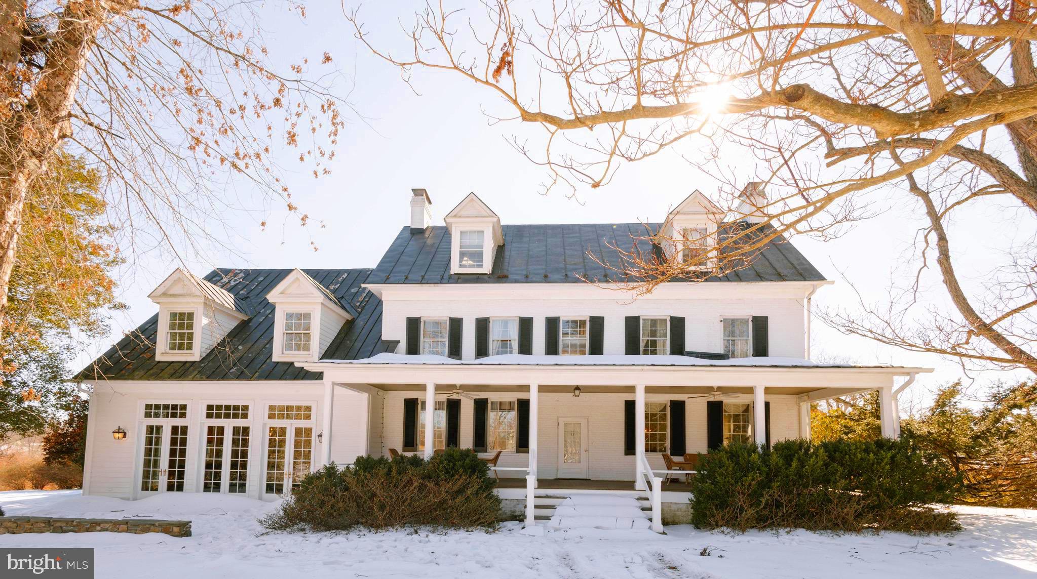 At the end of a gently winding country road, where Loudoun County’s storied landscape unfolds in quiet beauty, there lies a place where history lingers and new memories are waiting to be written—37961 Forest Mills Road.
This remarkable estate tells a story nearly two centuries in the making.
Dating to approximately 1830, the main residence stands as a living piece of Virginia’s heritage—gracefully preserved and thoughtfully partially renovated in 2026 to honor its historic character while enhancing comfort for modern living. With six bedrooms, three full baths, and two half baths, the home offers both scale and intimacy. Set within a natural hollow and embraced by rolling hills and mature trees, the residence enjoys a rare sense of shelter and serenity—protected from the outside world, yet open to the beauty of the surrounding landscape. Here, sunlight filters softly through the canopy, and every season unfolds like a painting beyond your windows. Wide-plank floors, period details, and timeworn textures echo its past, while carefully updated spaces provide ease for today’s lifestyle. Each room feels deeply connected to the land, offering peaceful, private views in every direction.
The story extends well beyond the main home.
Across the property, a beautifully reimagined carriage house, fully renovated in 2026, offers two bedrooms and one bath—perfect for guests, extended stays, or income potential. A second residence, a charming colonial-style home with three bedrooms and two baths, adds further flexibility for multi-generational living or rental opportunities.
The land itself invites possibility. Two barns—one large and one medium-sized—stand ready for equestrian use, storage, or creative adaptation. A picturesque pond reflects the surrounding greenery, while a swimming pool provides a tranquil setting for relaxation and entertaining during warmer months.
And everywhere you look, there is history.
During the Civil War, the property served as a vital local supply post—its grounds quietly witnessing a defining chapter in the nation’s past. In later years, a noted National Geographic cartographer called this land home, drawn by its perspective and natural beauty. Even earlier, a natural water spring on the property served as an important watering site for the nearby village of Lincoln, making this land a place of gathering and sustenance for the community.
Even the trees here tell a story. Identified by a local arborist, the property is home to several rare and noteworthy tree specimens, adding both distinction and natural significance to the landscape.
Today, 37961 Forest Mills Road offers a rare blend of heritage and opportunity. The estate supports a range of uses, including private residential living, income-producing rentals with two additional homes, or hospitality ventures such as a bed and breakfast, vacation rental, or wedding and event venue. All of this is protected within a conservation easement, preserving the land’s beauty and ensuring its legacy endures.
Here, life unfolds differently. Mornings begin with mist rising through the hollow, afternoons stretch across open fields and shaded paths, and evenings settle gently beneath a canopy of stars. It is a place of quiet refuge, rich history, and endless potential.
More than an address, this is a legacy—
a story rooted in the land, waiting for its next chapter to be written.