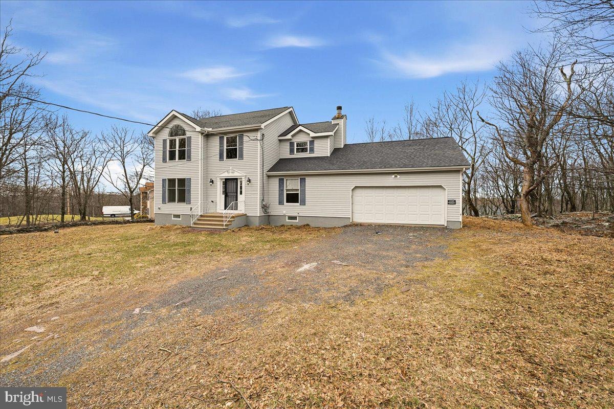 Welcome to 2026 Candlewood Dr — a fully renovated colonial set on a private wooded lot with mountain views. No detail was overlooked in this top-to-bottom transformation featuring luxury vinyl plank flooring throughout, an open-concept chef's kitchen with white shaker cabinets, quartz countertops, center island, and a full stainless steel appliance package. The light-filled family room showcases exposed wood beam ceilings and a classic brick fireplace — the heart of the home. Upstairs, the primary suite impresses with a dramatic arched window, vaulted ceiling, dual closets, and a spa-inspired en-suite with a floor-to-ceiling marble tile walk-in shower. Two additional full baths serve the remaining bedrooms. Step outside to an expansive rear deck overlooking mature trees for ultimate privacy. The massive finished basement adds serious square footage with multiple flex zones and a dedicated laundry room. Oversized 2-car garage completes the package. Rare opportunity — move-in ready, no compromises.