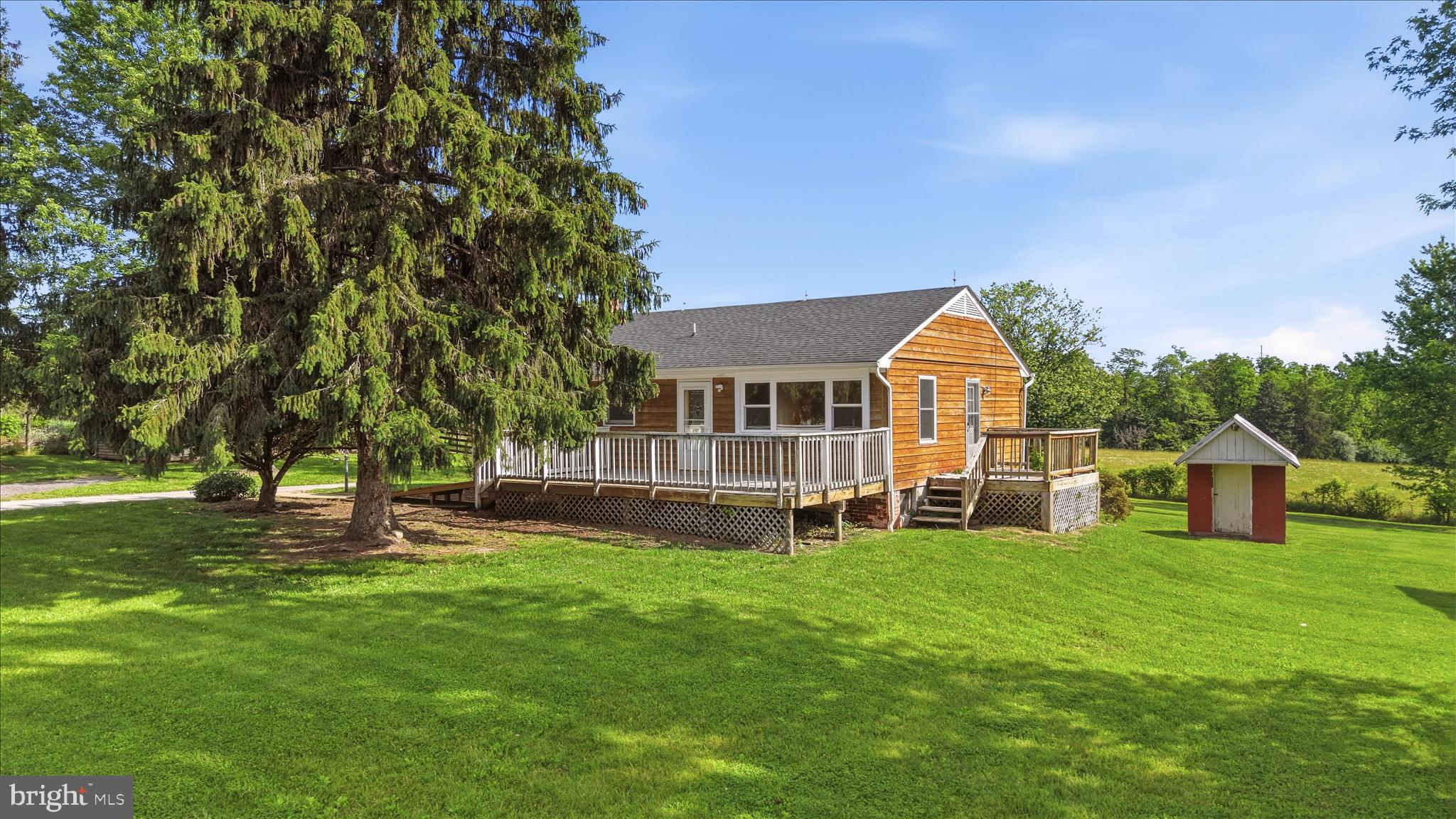 Opportunity awaits on 5 unrestricted acres in a fantastic location! This property offers plenty of space for hobbies, storage, animals, or future projects with a huge 28' x 30' garage with electricity, a barn, and multiple sheds. The home features several decks perfect for enjoying the peaceful setting and outdoor living. Major updates include a newer roof, heat pump, and some replacement windows. Multiple heat sources provide flexibility and comfort, including a newer heat pump with central air, a wood stove, and oil heat. A versatile property with endless potential in a desirable location! NOTE: This was built as a 3 bedroom 1 bath home with laundry in the basement - it was converted to a 2 bedroom to bring the laundry to the main level. It CAN be converted back to a 3 bedroom.  Home is sold strictly AS-IS.