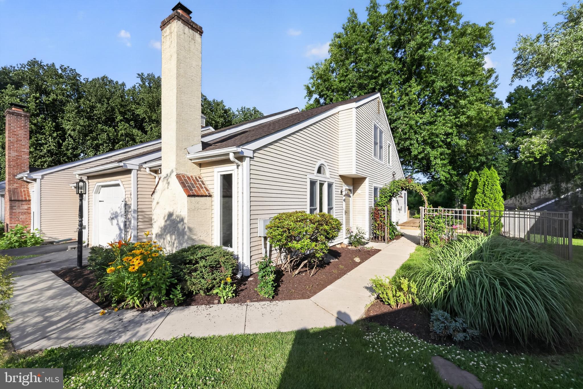 Nestled beneath a canopy of mature trees, this beautifully maintained 3-bedroom, 2-bath twin in Summit Trace offers comfort, style, and exceptional convenience. Thoughtfully updated throughout, the home features a remodeled kitchen with granite countertops, tile backsplash, center island, and ample cabinetry, along with two tastefully renovated bathrooms.  The inviting floor plan includes a spacious living room highlighted by a fireplace, a formal dining room, and a convenient laundry room with direct access to the garage. Hardwood flooring enhances the main living areas, while brand-new carpeting adds warmth and comfort to the bedrooms.  The first-floor primary suite offers a walk-in closet, ceiling fan, and direct access to a beautifully updated full bath. A second bedroom on the main level provides flexibility for guests, family, or a home office. A distinctive circular staircase leads to the upper level, where a loft with hardwood flooring overlooks the home and offers direct access to a full bath and an oversized walk-in closet. The third bedroom is also located on this level and features skylights and a ceiling fan, creating a bright and inviting retreat.  Outside, professionally landscaped side and rear yards provide a peaceful setting for relaxation and entertaining, complete with a spacious deck and patio for enjoying the outdoors day or night.  Ideally located near shopping, dining, schools, parks, and recreational opportunities, with easy access to major highways and rail service, this home offers the perfect blend of tranquility and convenience—a true commuter’s delight.