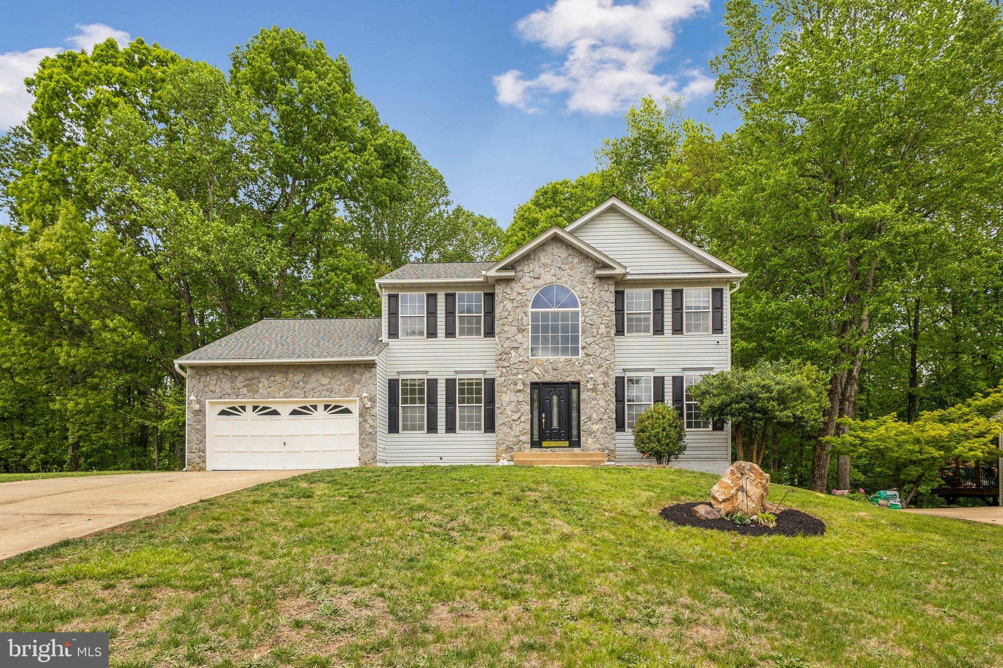 PRICED TO SELL.  $150k lower than new home development across from this community and more square footage. No home to sell contingencies.

Immaculate Colonial on Nearly Half an Acre Backed to Woods!
Discover over 5,000 sq ft of living space in this stunning 6-bedroom, 3.5-bath stone-front colonial, nestled on a private .46-acre lot with a fully fenced backyard. This move-in-ready home boasts 3 fully finished levels with fresh paint throughout and luxury vinyl plank flooring on the main level.

Step into a grand 2-story foyer with a sweeping staircase with private office and elegant living and dining rooms. The gourmet kitchen features granite countertops, stainless steel appliances, a cooktop island, and generous table space—plus a walkout to a private deck with serene wooded views. The adjacent family room is bathed in natural light with floor-to-ceiling windows and a cozy fireplace.

Upstairs, retreat to an oversized primary suite with an expansive walk-in closet and spa-style bath featuring a soaking tub, walk-in shower, dual vanities, and private water closet. The secondary bedrooms are carpeted and share a spacious hall bath. Upgrades Galore.

The fully finished lower level includes two additional bedrooms, a full bath, and a large laundry room—perfect for a guest suite, in-law retreat, or multigenerational living. Walk out to a fully fenced backyard that backs to mature trees.

This home has it all: size, privacy, elegance, and flexibility for today's lifestyle!