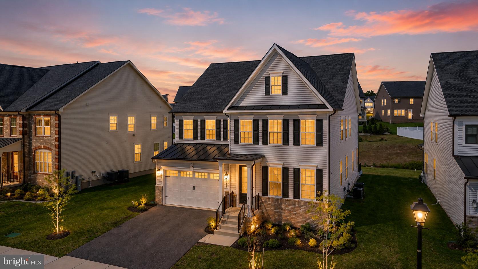 Welcome to 7949 Lawndale Circle — a rare offering that redefines luxury living in Columbia, Maryland. Nestled within the highly sought-after Cedar Creek community and zoned to the acclaimed River Hill High School and Clarksville Middle School, this exceptional Northeast-facing NV Homes Tyler model offers over 5,200 square feet of meticulously curated, fully finished living space where every detail has been thoughtfully elevated. A striking white façade accented by bold black shutters, a covered portico, expansive driveway, and two-car garage establish an elegant first impression, while the premium lot backing to protected open space offers a rare sense of privacy and tranquility. Inside, sun-drenched interiors unfold with wide-plank 9.5” luxury vinyl flooring, extensive crown molding, upgraded lighting, and a sophisticated neutral palette throughout. The home seamlessly blends formal living and dining spaces with an extraordinary chef’s kitchen featuring an oversized quartz island, 42” snow-white soft-close cabinetry, designer backsplash, double wall ovens, five-burner cooktop, externally vented hood, stainless steel appliances, dedicated coffee station, oversized walk-in pantry, and thoughtfully designed mudroom access. The adjoining breakfast area and expansive family room are flooded with natural light from upgraded additional windows and effortlessly extend to the outdoor living space overlooking serene open views — creating the perfect setting for elevated everyday living and seamless entertaining. Upstairs, the luxurious owner’s suite is privately tucked behind French doors and showcases tray ceilings with crown molding, dual oversized walk-in closets, and a spa-inspired en-suite bath complete with a soaking tub, frameless glass shower, dual vanities, and private water closet. A signature upper-level loft unique to this model offers exceptional flexibility for a media lounge, office, or secondary living space, while three additional spacious bedrooms feature generous walk-in closets, including a private en-suite and a well-appointed Jack-and-Jill bath. The fully finished lower level, completed in 2024, expands the home even further with an expansive recreation area, bonus/media room pre-wired for a projector, full upgraded bathroom, abundant storage, and walk-up access. Additional upgrades include a whole-house humidifier, dual Nest thermostats, insulated dual-pane windows, smart lighting throughout bedrooms, moisture-barrier carpet padding, custom double-cellular blackout window treatments, active radon mitigation system (2024), and an electric vehicle charging station. Cedar Creek offers scenic walking trails, playgrounds, open green spaces, and convenient access to US-29, I-70, and I-95, placing Baltimore, Washington, D.C., shopping, dining, and everyday conveniences within effortless reach. Impeccably maintained, extensively upgraded, and thoughtfully designed, 7949 Lawndale Circle represents one of Columbia’s premier turnkey luxury opportunities.