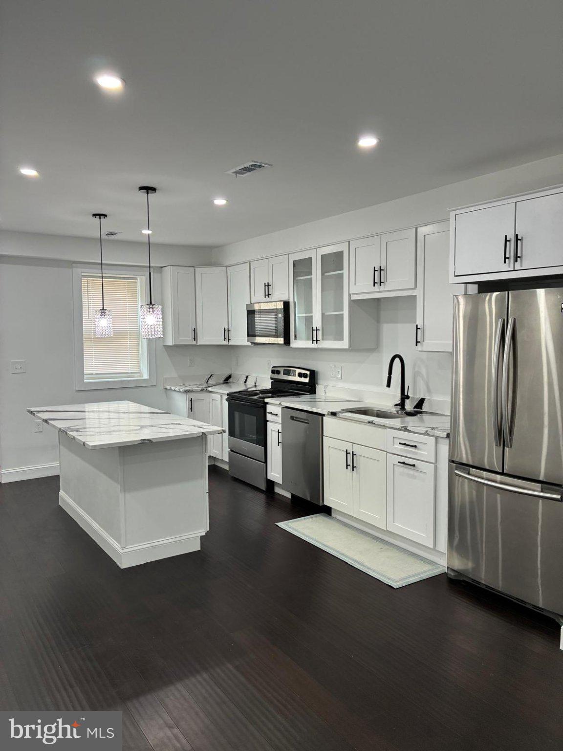 Nestled in the charming Broadway East neighborhood, this exquisite end-of-row townhouse seamlessly blends contemporary design with timeless elegance. With a major renovation completed in 2026, this home offers a luxurious lifestyle that caters to both comfort and sophistication. Step inside to discover an inviting open floor plan that effortlessly connects the living, dining, and kitchen areas. The heart of the home features upgraded countertops and a spacious kitchen island, perfect for culinary enthusiasts and entertaining guests. The eat-in kitchen is adorned with high-end appliances, including a built-in microwave, electric oven/range, and a sleek refrigerator, ensuring every meal is a delight. Recessed lighting and ceiling fans enhance the ambiance, while the rich wood floors and ceramic tile add warmth and character throughout. This residence boasts four generously sized bedrooms, providing ample space for relaxation and personalization. The three full bathrooms and one half-bath are designed with modern fixtures and finishes, offering both style and functionality. The main floor laundry adds convenience to your daily routine, making chores a breeze. Venture downstairs to the partially finished basement, which offers endless possibilities for customization-whether as a cozy retreat, a home gym, or additional storage. The interior access and connecting stairway ensure easy movement throughout the home. Outside, the property is framed by charming sidewalks, inviting you to explore the vibrant community. While there is no pool, the low-maintenance lot size of 0.03 acres allows for easy outdoor enjoyment without the burden of extensive upkeep. On-street parking provides convenience for you and your guests. With double-pane insulated windows, this home is designed for energy efficiency, ensuring comfort year-round. The combination of brick and aluminum siding not only enhances the exterior aesthetic but also promises durability and low maintenance. This property is more than just a house; it's a lifestyle choice that offers a perfect blend of luxury, comfort, and community. Experience the best of contemporary living in a home that truly feels like a sanctuary. Don't miss the opportunity to make this exceptional residence your own.