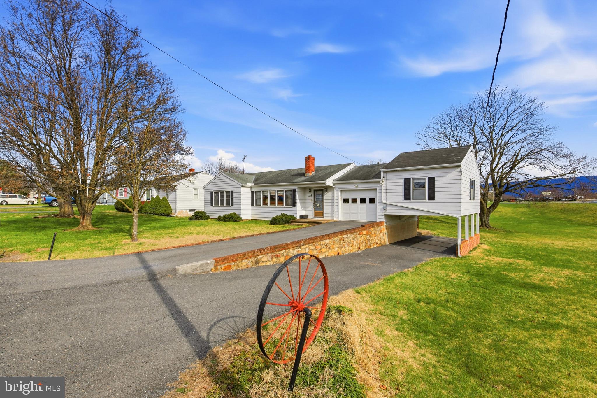 Charming ranch in the heart of Woodstock — just one block from shopping and dining. This solid and bright 4-bedroom, 2-bath home includes a versatile elevated office that is attached to the garage and can easily serve as the fourth bedroom.  The full basement is dry and features built-in work benches for projects and storage, a self contained tanning room (as is), and a water mitigation system installed and inspected annually by JES Foundation Repair.  Bring your personal design ideas to the interior and modernize as you see fit.
Outside, enjoy your privacy on the large back deck overlooking your .64 acre double lot!  There is abundant space for gardening, play, entertaining and pets.  If you have multiple vehicles, boats, lawn tractor equipment or just want a large workshop, be sure to tour the 28'x32' detached building.  It's already equipped with 2 garage doors, power, concrete floor and tons of storage space! 
Enjoy easy, comfortable living with the benefits of a large yard and mountain views, but the convenience of downtown amenities 1 block away.   Woodstock has incredible small town charm but is also half way between two major cities with their own culture, history and colleges; Winchester and Harrisonburg.  With I-81 only 2 blocks away, both are a short drive.   Schedule a showing today!
Active security cameras inside the home.