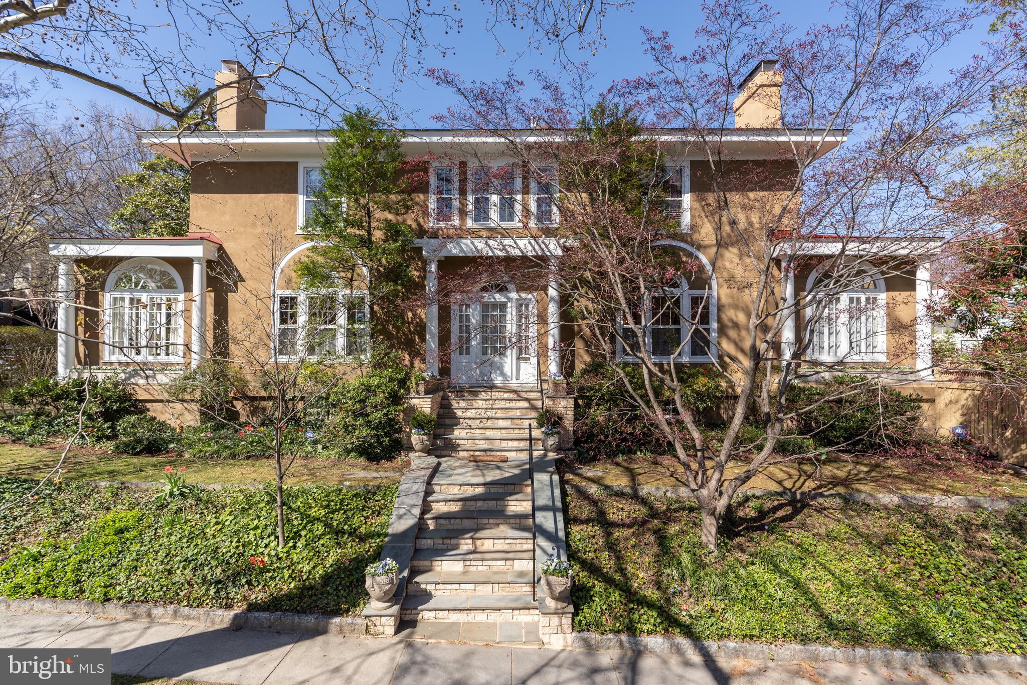 Introducing a timeless masterpiece: a stunning 1920’s neo-classic Italianate mansion boasting over 8,500 interior square feet, nestled on a large corner lot in prestigious Observatory Circle, just blocks from the Vice President’s residence, the National Cathedral and Embassy Row. This architectural marvel is a perfectly symmetrical manse, adorned with grand Palladian windows and striking exterior, providing the perfect sanctuary for the most discerning of homeowners. The stately center hall and wide main staircase with mahogany railings set a grand tone from the moment you enter, and the gorgeous wood floors, 6 fireplaces, and intricate crown molding add to the classic elegance of this home. The spacious main level beckons with graceful proportions and sun-drenched spaces, offering multiple rooms for entertaining and relaxing: formal living and dining rooms, family/TV room, two sunrooms on opposite wings of the home, a library with floor-to-ceiling built-in bookshelves, a large, gourmet eat-in kitchen, and a full bath. On the second floor, discover 4 bedrooms with 3 full baths, including the luxurious primary suite boasting two walk-in closets, fireplace, a large ensuite bath with two vanities, two water closets, double shower, jacuzzi tub, plus adjoining gym space and laundry area, as well as a separate, sunny home office. The third floor offers two additional bedrooms, a full bath with skylight, and ample storage. The lower level of this distinguished home boasts a large 2BR/1BA in-law suite with full eat-in kitchen, living room, laundry area and separate entrance, along with plenty of storage space. A 2-car attached garage completes the package. Outside, an expansive deck offers the perfect space for al fresco gatherings or peaceful mornings, surrounded by lush landscaping and mature plantings that ensure privacy and tranquility. There is also a sunlit garden on both the eastern and western expanses of the lot. Situated in one of Washington D.C’s most sought-after neighborhoods, you’ll be in close proximity to top schools, parks, shopping, and all the cultural delights the city has to offer. This is a home without compromise.