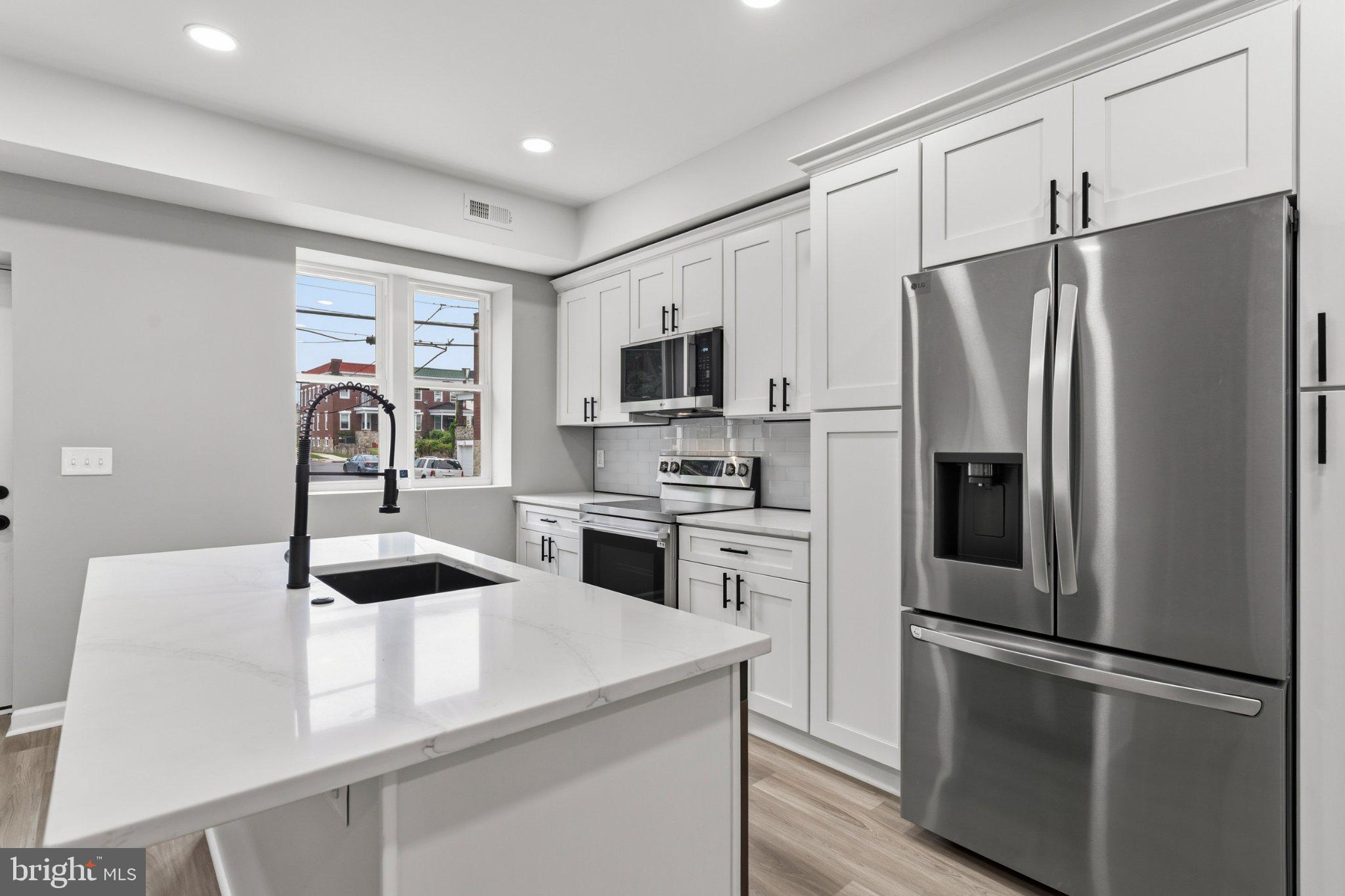 Completely rebuilt from top to bottom, this stunning end-of-group rowhome offers the perfect combination of modern finishes and peace of mind with virtually everything brand new. Featuring 3 bedrooms, 2 full baths, and 1 half bath, this home boasts an open-concept main level with luxury flooring, recessed lighting, and a designer kitchen complete with shaker cabinetry, quartz countertops, a large center island, subway tile backsplash, and stainless steel appliances... Upstairs you'll find a spacious primary suite with a private full bath, plus two additional bedrooms and another beautifully updated full bathroom. This is not just a renovation, it's essentially a brand-new home inside and out. Don't miss your opportunity to own this beautifully transformed property.