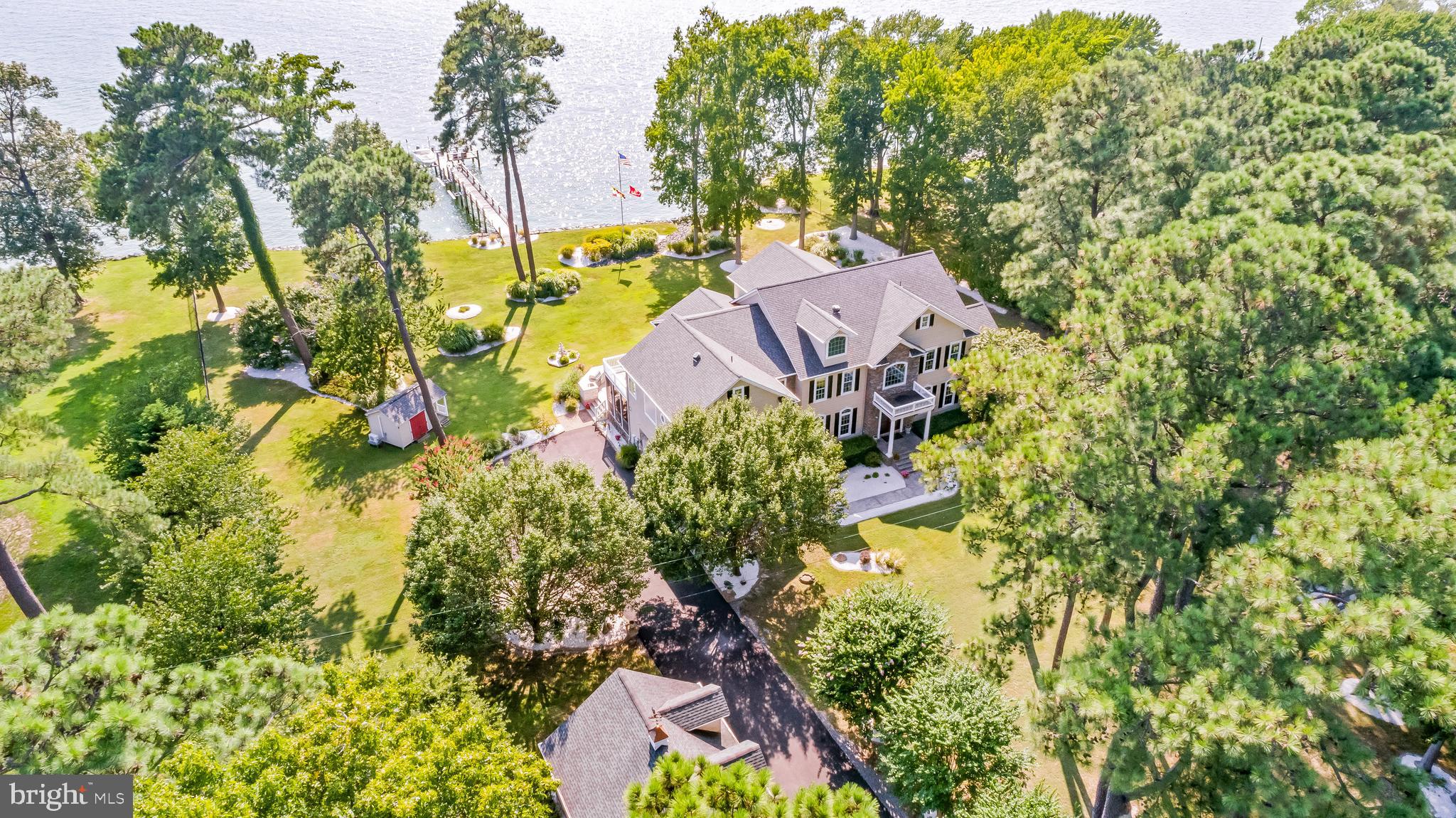 Discover the quintessential Southern Maryland waterfront lifestyle, situated on a stunning 2-acre parcel in beautiful St. Georges Island. Enjoy westerly panoramic Potomac views, and the Virginia shoreline on the horizon. Enjoy early evening hours drenched in sunset. Watch boats pass all day long, as well as watermen hauling in crab pots. Located on the lower Potomac, just 10 nautical miles to the Chesapeake Bay, and the area's best fishing grounds for striped bass. Boaters are within 70 NM to DC, 65 NM to Annapolis, and 75 NM to Virginia Beach. Coastal living at its best, with 200' of rip-rap waterfront, a 125' pier with 10,000 lb boat lift, and two jet ski lifts. MLW 4-5'. Bring your boat, your friends, kayaks, crab pots, fishing rods! Wrap the day up with a cookout/crab feast on the expansive back deck, complete with a granite topped full outdoor kitchen/gas grill, a 7-seat hot tub, a resplendent green lawn, and a comfortable screened porch to watch the river in all weather! The relaxing lifestyle continues indoors, with many features to enjoy, such as the 22' tall coffered ceiling and stone fireplace in the great room, with broad water views. The open kitchen offers all the quality appliances, gorgeous granite counters, ample storage, custom cabinetry, and more, to create sumptuous meals and feasts. The adjacent butler's pantry provides a prep sink, more cabinetry and the primary laundry room; an additional pantry is located off the breakfast area. A sitting room, parlor, study, two additional fireplaces, and large DR allow for flexible living space and plenty of flow for entertaining, whether large parties or intimate gatherings. The graceful curved staircase leads to the second story, with dazzling views of the water. Two spacious bedrooms with a shared remodeled hall bath lie at one end of this level, with a third en suite guestroom and the primary bedroom suite on the other side. You may never want to leave the primary bedroom, with all that it has to offer! Windows galore, a sitting area with private fourth FP, a spa of a bathroom, with access to a private balcony, sauna, luxury shower and garden tub, dressing room, and separate laundry room, complete with coffee station, beverage fridge, and microwave. The third floor serves as the 5th bedroom/additional guest suite, with a full bath, wet bar, built-ins, several closets, and one of three Juliet balconies for yet another perch to enjoy the gorgeous view. Very privately situated, the property is secured by an automatic gate and fully fenced. Plenty of wildlife still manages to grace the property! Boats, cars, and outdoor toys can be stored in the detached oversized 2-car garage, with more storage above, and an attached 2+car garage nicely accommodates all the vehicles. An adorable potting shed has both electric and heating/air and could make a nice art studio. Newer generator installed. A garden shed and multiple frost proof yard hydrants allow for easy lawn maintenance. Simply stunning landscaping, with flower beds, crepe myrtles, and tall shade trees. Truly, you must see it all for yourself! St. Georges Island is 1.5 hours to Washington. No need to contend with Bay Bridge traffic to escape to your island getaway! Piney Point boat ramp and the Ruddy Duck Seafood & Ale House are just 1.5 miles away. Nearby Piney Point Lighthouse makes for a nice bike ride destination. Convenient marine service is available just across the Potomac, at Coles Point Marina. 30 min. to NAS Patuxent River, 30 min. to St. Mary's Hospital and charming Leonardtown.