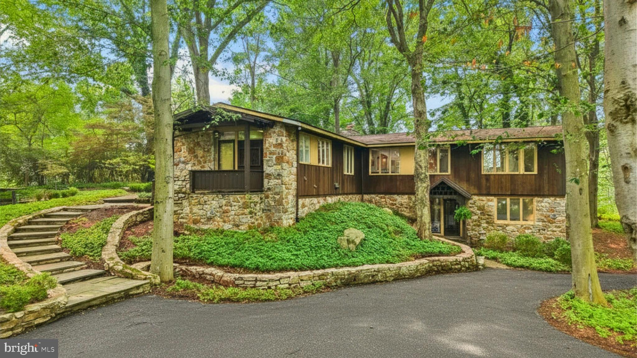 A wooded drive climbs, gradually, to an incredible vantage point, positioned to take full advantage of the surroundings.  This dramatic home was created by the noted architect, S. Harmon “Bugs” Brown, with an eye to combining space, light and imagination.  Set amidst old trees on 3.15 acres in the coveted environs of Old Weyhill, the house is perched above the Weyhill Golf Course on the south side, while overlooking a ten acre, private pond to the north.
Inside, warm wood flooring and stunning window placement set the mood for the perfect retreat.  This brilliant design was created for the architect’s own personal residence, on acreage available only through a private purchase from Bethlehem Steel. The resulting achievement is a spacious, airy, light-filled home that makes you feel connected to the treetops.  Vast windows and glass doors welcome the four seasons.  The main floor, with walls of glass, is an intriguing combination of spaces, offering living room, family room, dining room, and kitchen.  The primary bedroom suite boasts stunning views, a separate office, and a three-part bath.  Two additional bedrooms and bath are on the entry level.   
The Old Weyhill neighborhood, with unparalleled privacy, welcomes one to renovate, update or build new.  This secluded acreage is set far back from the private roads. It overlooks over 800 acres of the Saucon Valley Country Club and is only a short walk or golf cart ride to the Weyhill Golf Course Clubhouse and the country club amenities beyond.  Rarely does a property such as this become available in such a location … offering SVCC roads for walking, all enveloped by the beauty of the natural environs.