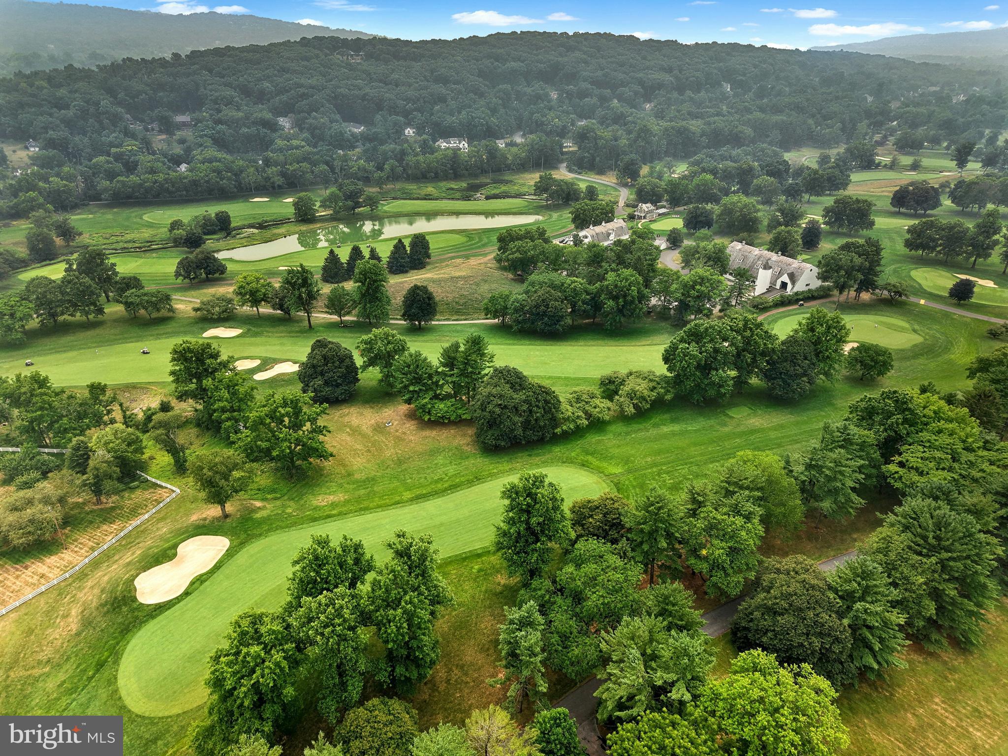ON THE WEYHILL GOLF COURSE AT SVCC…..A wooded drive climbs, gradually, to an incredible vantage point, positioned to take full advantage of the surroundings.  This dramatic home was created by the noted architect, S. Harmon “Bugs” Brown, with an eye to combining space, light and imagination.  Set amidst old trees on 3.15 acres in the coveted environs of Old Weyhill, the house is perched above the Weyhill Golf Course on the south side, while overlooking a ten acre, private pond to the north.
Inside, warm wood flooring and stunning window placement set the mood for the perfect retreat.  This brilliant design was created for the architect’s own personal residence, on acreage available only through a private purchase from Bethlehem Steel. The resulting achievement is a spacious, airy, light-filled home that makes you feel connected to the treetops.  Vast windows and glass doors welcome the four seasons.  The main floor, with walls of glass, is an intriguing combination of spaces, offering living room, family room, dining room, and kitchen.  The primary bedroom suite boasts stunning views, a separate office, and a three-part bath.  Two additional bedrooms and bath are on the entry level.   
The Old Weyhill neighborhood, with unparalleled privacy, welcomes one to renovate, update or build new.  This secluded acreage is set far back from the private roads. It overlooks over 800 acres of the Saucon Valley Country Club and is only a short walk or golf cart ride to the Weyhill Golf Course Clubhouse and the country club amenities beyond.  Rarely does a property such as this become available in such a location … offering SVCC roads for walking, all enveloped by the beauty of the natural environs.