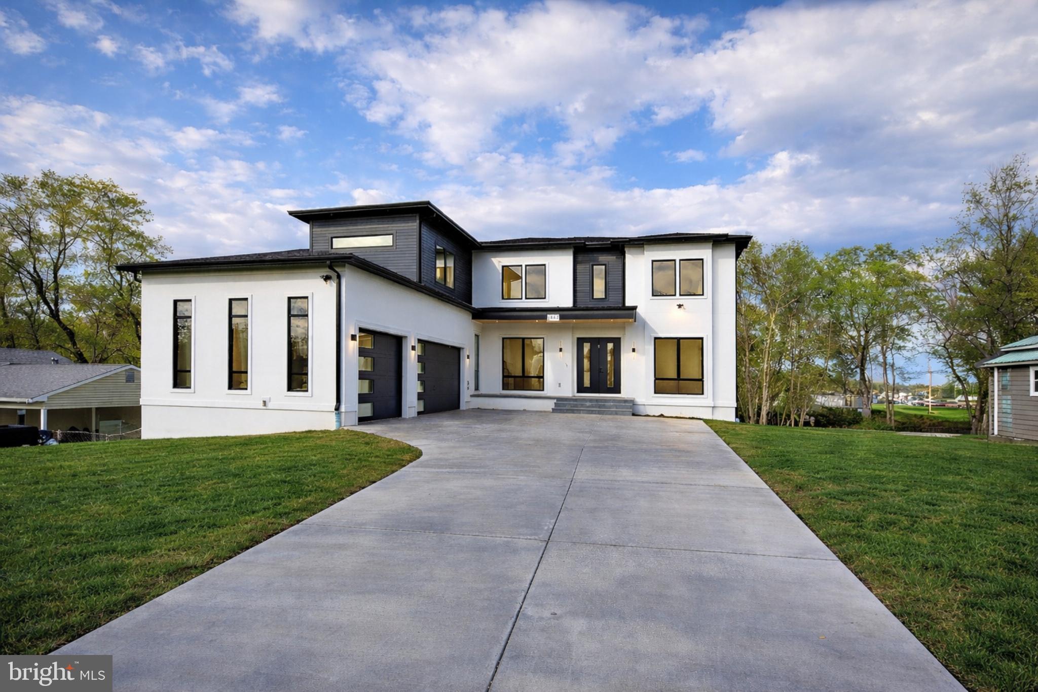 Opulux Homes presents a premier custom luxury residence set on an expansive .58-acre lot in one of Vienna’s most desirable locations.

Spanning over 7,800 square feet, the home features 7 bedrooms, 7.5 bathrooms, an upper-level loft, and an oversized three-car garage—thoughtfully designed to deliver both grand-scale entertaining and refined everyday living.

The striking exterior is defined by floor-to-ceiling Andersen 400 Series windows, filling the home with natural light and creating a seamless connection between indoor and outdoor spaces.

Inside, a sophisticated open-concept layout unfolds with expansive living and dining areas and a sunlit family room anchored by a sleek linear fireplace. Expansive 8-foot sliding glass doors open to a covered composite deck, creating a true indoor-outdoor living experience.

The chef’s kitchen is both functional and architectural, featuring premium appliances, European-style dual-tone cabinetry, and an oversized quartz island, complemented by a fully equipped spice kitchen.

A main-level bedroom suite offers flexibility for guests or multi-generational living.
Upstairs, four spacious en-suite bedrooms accompany a private primary suite designed as a true retreat. The primary suite features a sitting area with a fireplace, a private beverage bar, and large windows overlooking the backyard. A boutique-style walk-in closet with a center island enhances the suite’s custom design.

The spa-inspired primary bathroom delivers elevated comfort and privacy, featuring dual water closets, an oversized walk-in shower with dual rain heads and body jets, and refined, high-end finishes.
A versatile loft with a full picture window completes the upper level, ideal for a lounge, workspace, or additional living area.

The fully finished walkout lower level is designed for elevated entertaining, offering a recreation room, full bar, fireplace, pre-wired media room, two additional bedrooms, and a dedicated exercise room.

Throughout the home, Opulux’s commitment to craftsmanship is evident with 10-foot ceilings on the main and upper levels, 9-foot ceilings on the lower level, custom cabinetry, premium porcelain tile, modern railings, tray ceilings, and layered LED lighting.

Constructed with a focus on quality and performance, the home features 2x6 exterior framing, upgraded foam insulation, enhanced subflooring, extra-wide foundation walls, PVC trim with James Hardie soffits, architectural shingles, a high-efficiency HVAC system, and an EV charging outlet.

A rare opportunity to own a newly built luxury residence in Vienna with exceptional design, scale, and craftsmanship. Photos are of the actual home and include virtual staging.