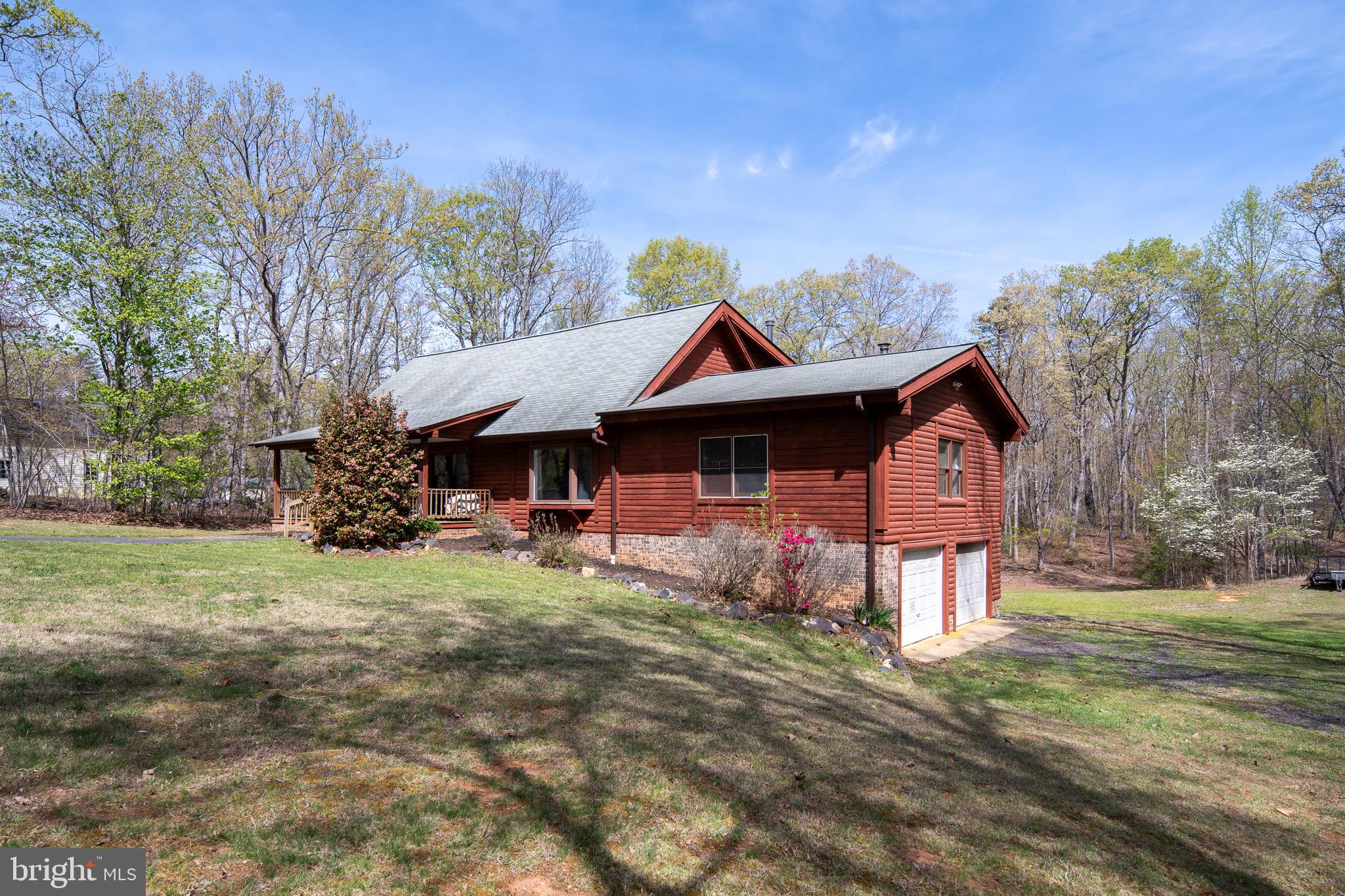 Tucked away in the peaceful woods of Spotsylvania County, this one-of-a-kind log home offers the kind of privacy, space, and lifestyle that buyers are searching for right now, but rarely find. Set on 5+ acres, this modern Cape Cod–style log cabin blends rustic charm with everyday comfort, creating a true retreat that still keeps you connected to everything you need.

From the moment you arrive, you feel it—the quiet, the space, the sense of stepping away from the busy pace of life. Whether you're enjoying your morning coffee on the front porch or unwinding in the evening surrounded by nature, this property is designed for those who value privacy, serenity, and room to breathe.

Inside, the home welcomes you with soaring vaulted ceilings, exposed wood beams, and a warm, lodge-style feel that brings the outdoors in. The open layout is built for real living and entertaining, with the kitchen at the center—featuring granite countertops, stainless steel appliances, a breakfast bar, and easy flow into both the great room and family room.

The main-level primary suite offers the convenience so many buyers want, complete with an en suite bathroom and a relaxing jetted tub. Upstairs, you’ll find two spacious bedrooms with stunning cathedral ceilings and a full bathroom, perfect for guests, family, or flexible living.

The finished walkout basement adds even more usable space with a large recreation or flex room, complete with a second wood stove, ideal for a home theater, gym, or game room. 

This property is just as impressive outside. Enjoy expansive front and rear porches, multiple outbuildings including a detached garage/workshop with electricity, plus an oversized carport, perfect for hobbies, storage, or all your outdoor toys.

Located just minutes from Wilderness Run Vineyards and 1781 Brewing Company, and a short drive to Culpeper, Charlottesville, and surrounding counties, this home offers the perfect balance of peaceful living and accessibility. You’re also close to golf, lakes, and historic sites that make this area so special.

If you’ve been searching for a private acreage home in Spotsylvania County, a log cabin with modern updates, or a place where lifestyle meets comfort and space, this is it.