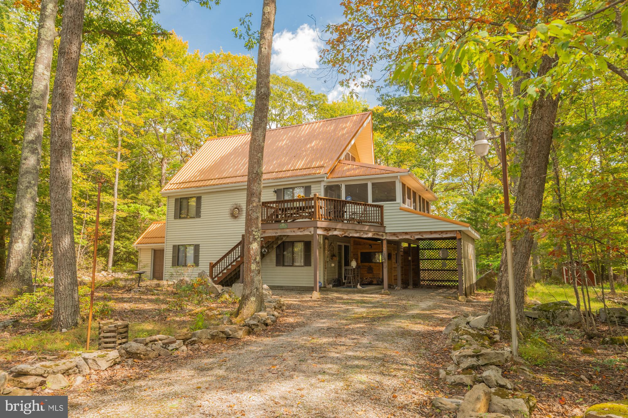 Tucked away in the woods on 1.72 acres, this stunning 4-bedroom, 2.5-bath mountain retreat offers privacy, comfort, and plenty of space to unwind. Step inside to find a warm and inviting main level highlighted by a stone fireplace, cozy dining area, and galley-style kitchen. Relax on the screened-in porch complete with a hot tub under roof, perfect for year-round enjoyment. The finished basement is an entertainer’s dream, featuring a pool table, wood stove, mudroom, half bath, and a bedroom with its own attached full bath—ideal for guests. Additional features include an attached 1-car garage, carport beneath the covered deck, and a layout designed for both everyday living and mountain getaways. Lovingly maintained and in excellent condition, this home combines rustic charm with modern comfort in an incredible setting. Located within the gated recreation community of Yough Mountain Resort, you'll have access to over 50 miles of ATV, snowmobile, and hiking trails, as well as river access, fishing, and hunting. For those seeking even more adventure, Deep Creek Lake, the town of Oakland, Swallow Falls, and Herrington Manor State Park are just minutes away, offering endless possibilities. Call today!