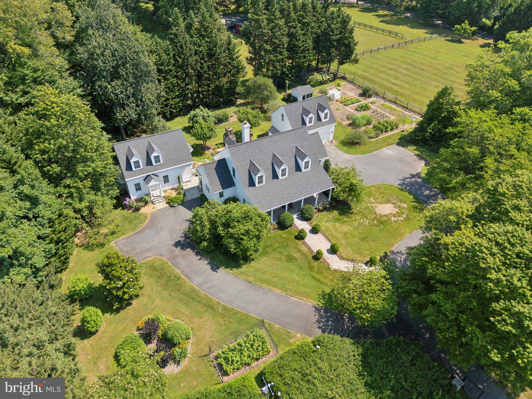 Welcome home to this idyllic, gated oasis comprised of a one-of-a-kind, custom-built compound nestled in the heart of Great Falls. Set well off the road on 2.5+ acre for privacy, this stunning property includes the main house, separate in-law cottage, detached two-car garage with living space above, impressive organic vegetable and flower gardens, and expansive lawns. The upper acre is surrounded by a 10-foot deer fence to allow for gardening. Read on for more information and request document for a comprehensive list of details, too many to list here! Total of 6 BR 4.5 baths among the 3 structures. 

Main House -4BR 3.5 BA  (4016 SF ) custom built by Kohler homes. The deep front porch invites you into the 2-story foyer that is flanked by an office with custom built-ins to the left and the spacious formal dining room to the right. Columns in the dining room match the columns on the front porch. As you walk forward from the foyer to the family room, your eyes will be drawn to the view of the beautiful back yard through French doors that lead out to the flagstone patio with custom masonry fireplace with a lovely iron detail from Cape May. The generous family room with custom built in cabinets, wood burning fireplace with granite surround and hearth, and detailed crown molding is just off the chef’s kitchen. Preparing meals for friends and family will be a delight in this beautiful space with custom Tedd Wood cabinets, large island with seating, Subzero refrigerator, GE Monogram under-counter refrigerator, Thermador glass cooktop, Bosch dishwasher, two sinks, granite counters, reverse osmosis water system, walk-in pantry, and remote-controlled honeycomb blinds. Also off of the kitchen is a convenient laundry/mudroom and side entrance. 
Rounding out the main level is the primary suite with two walk-in closets, elegant bathroom with his and her sinks, heated floors and shower walls, walk-in shower with glass surround and door, separate tub, separate water closet, custom cabinets, and remote-controlled honeycomb blinds over the tub. French doors leading Upstairs you will find two large bedrooms with large closets, and a shared Jack and Jill bath along with a linen closet. 
The finished basement includes a large gym, media room with surround sound, bedroom with large closets (currently being used as an office), full bathroom, and other finished and unfinished storage areas. The heating system in the utility room is a work of art!
Throughout this incredibly well-built custom home you will find hardwood floors, 6” exterior walls for extra insulation, radiant gas heat, tall base boards, deep crown molding, Lutron Maestro switches, and recessed lights galore. Sliding covers on outlets for safety and insulation. 
The In-law cottage 1 BR 1 BA  (1586 SF ) was designed to complement the main house and greets with a delightful portico. Inside you will find a full kitchen with custom cabinets, granite counters, reverse osmosis water system, laundry closet & breakfast nook. The cottage is complete with a luxurious bath with spacious shower, main level bedroom, upstairs office/living room, and finished basement. Beautiful hardwood floors throughout living areas and tile in the bathroom and basement. Custom built in 2015 by local Foley Homes. 
The studio apartment  1 BR 1 BA (434 SF) above  the two-car garage is perfect for guests or an au pair. The kitchenette has a granite counter, custom Tedd Wood cabinets, GE under counter refrigerator/freezer, microwave and sink. The bath has granite counters, shower w/ glass door, and a Whirlpool Heavy Duty Twin-Thin stacked washer/dryer. New 3-Day Blind honeycomb shades on the windows and door. Your guests are sure to enjoy the beautiful view of the garden from the east window!
This serene setting is worlds away from traffic and noise yet close to shopping in Great Falls, Reston, Sterling and easy access to commuter routes; FFX County Pkwy, 267 and Reston Wiehle Metro. Langley High School pyramid