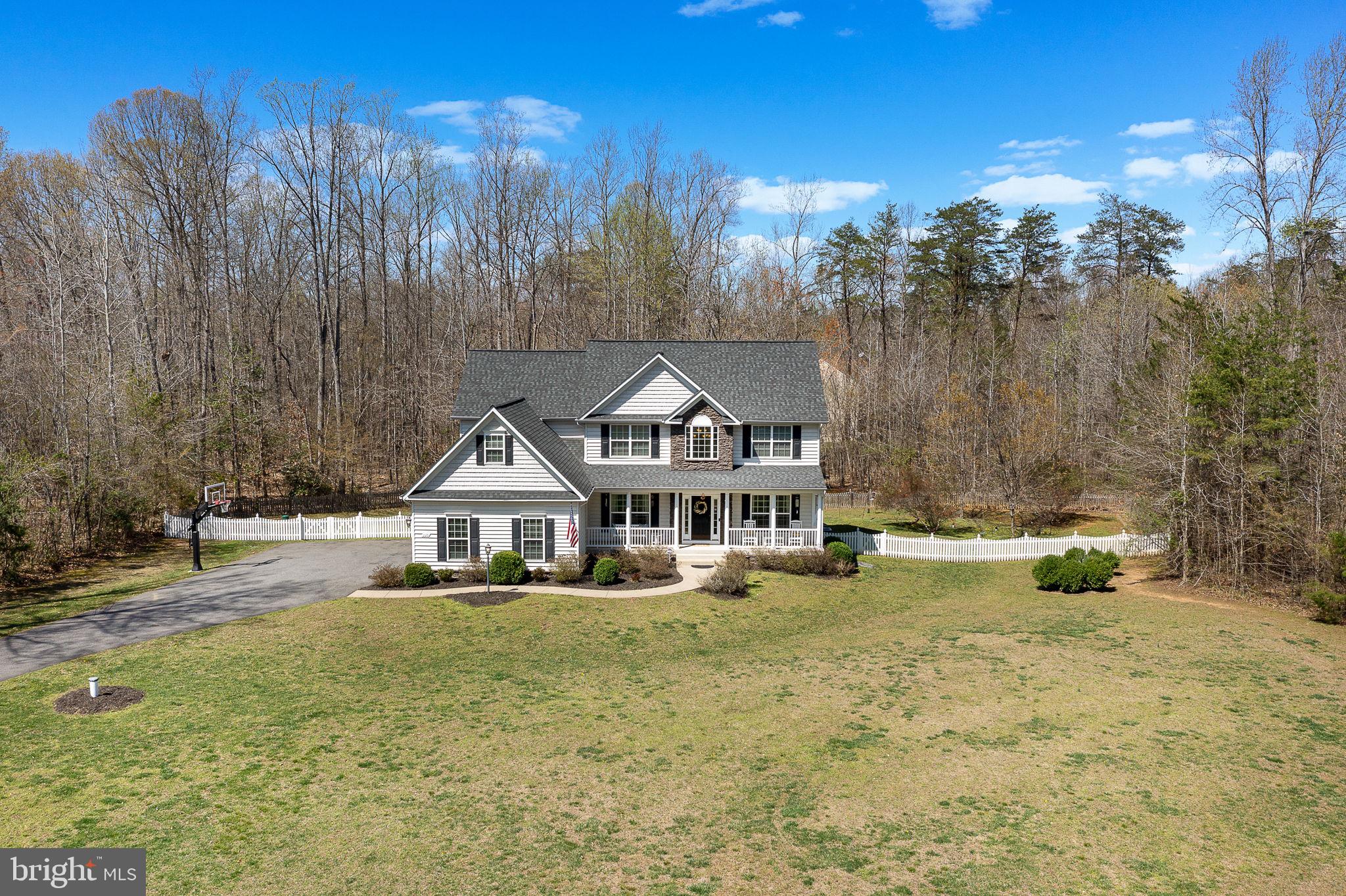 Welcome to your dream home! This stunning Colonial-style residence, built in 2014, offers a perfect blend of modern comfort and timeless elegance. Nestled on a generous 3-acre lot, this property is a serene retreat that backs to lush trees, providing a peaceful backdrop for your everyday life. Step inside to discover a warm and inviting interior featuring five spacious bedrooms and four and a half bathrooms. The open floor plan seamlessly connects the family room to the kitchen, making it an ideal space for gatherings and entertaining. The kitchen is a chef's delight, equipped with SS appliances, upgraded countertops, a double wall oven, a cooktop, and ample space for a breakfast area. Enjoy cozy meals in the dining area or step outside to the deck or patio for al fresco dining surrounded by nature. The fully finished basement, complete with a walkout entrance, offers additional living space perfect for a game room or home theater. Convenience is key with a main floor laundry area and an attached side-entry garage that accommodates three vehicles. The exterior of the home is equally impressive, featuring beautifully landscaped grounds with a level yard, perfect for outdoor activities. The partly wooded lot provides privacy and tranquility, while the no-thru street ensures a peaceful environment. Close to VRE, I95,  Quantico, shopping, historical sights and Crow's Nest.  This property is not just a house; it's a place to create lasting memories. Don’t miss the opportunity to make this inviting home yours!