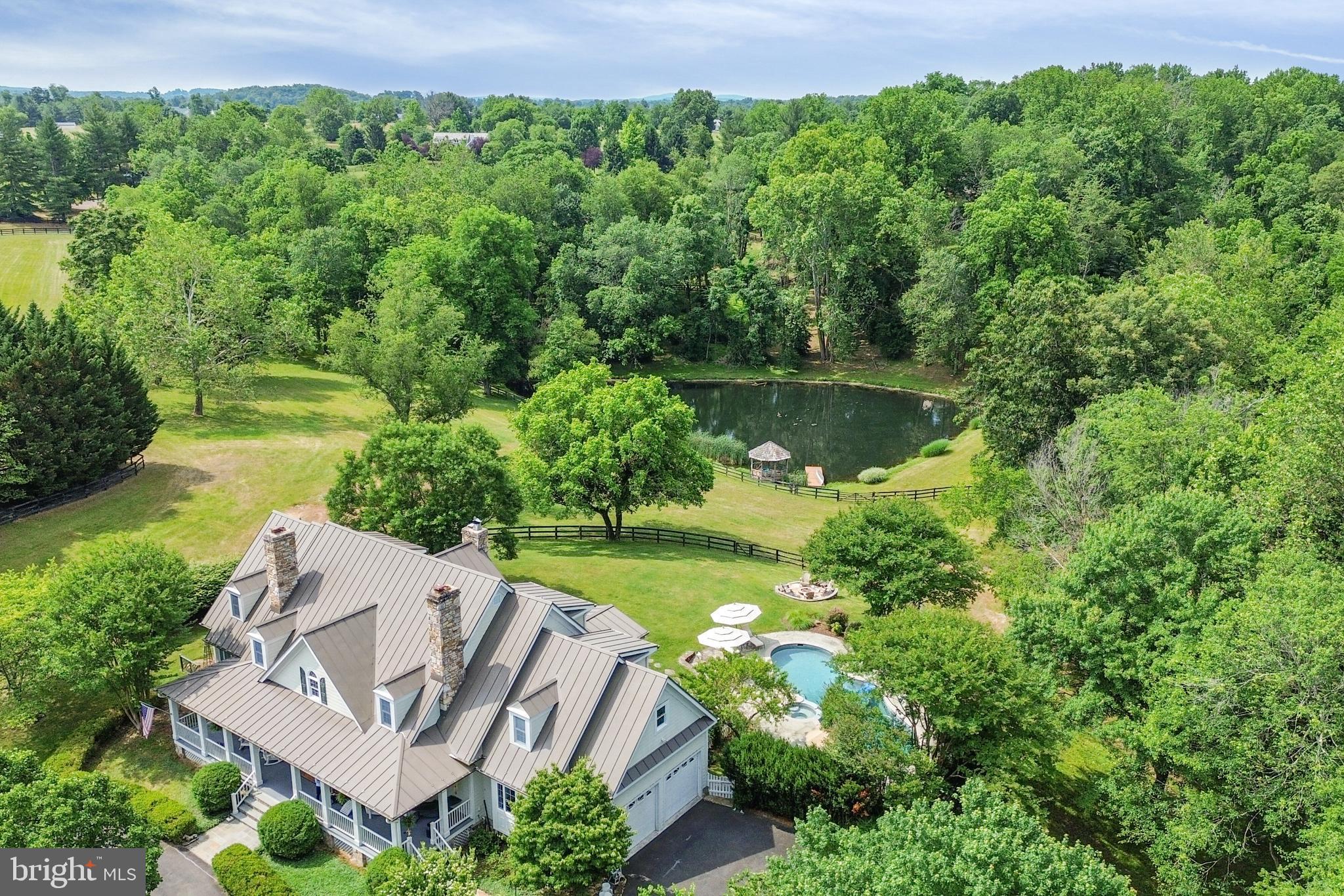 Welcome to 34840 Atoka Chase Lane, a captivating Cape Cod style retreat nestled on a private, serene 10.92-acre lot. This extraordinary home harmoniously combines timeless elegance, outdoor splendor, and modern luxuries. With 4 bedrooms, 4.5 baths, and three levels of refined living space, this residence offers an exceptional private sanctuary for the discerning homeowner.

As you step inside, you'll be immediately struck by the impeccable craftsmanship. The gourmet kitchen, a haven for culinary enthusiasts, opens up to a light-filled sunroom, creating an inviting space for gatherings and relaxation. Solid masonry construction ensures durability and longevity, while the thoughtfully designed layout flows seamlessly. You'll find four separate stone fireplaces throughout the home. Two of which are gas fireplaces. With a main level primary suite it is ideal for multigenerational families or those who prefer the convenience of a main level primary room.

Upstairs, you'll discover two more spacious bedrooms, a private office & a private loft sitting/family room providing a cozy nook for reading or unwinding after a long day. 

Venture downstairs to the spacious basement, an entertainer's dream. Here, you'll find plenty of space for storage, a gym/fitness room to keep you active and healthy, a recreation room for hosting game nights, a wet bar for crafting cocktails, and a private bedroom offering a tranquil retreat for guests or family members. This versatile space is perfect for entertaining and creating cherished memories.

Outside, a private oasis awaits. Lounge on the pergola-shaded patio, take a refreshing dip in the heated gunite pool, gather around the open fire pit to roast s'mores, or explore the lush garden beds, where you can cultivate your favorite plants and herbs. The peaceful ambiance of the property is enhanced by the tranquil shared pond, providing a serene backdrop for relaxation. The pond is stocked and there is a delightful gazebo nestled by the pond offering a picturesque spot to enjoy the gentle breeze and soak in the natural beauty that surrounds you. Adjacent to the gazebo, a small dock provides a perfect vantage point to observe the serene waters and perhaps even launch a  kayak for a leisurely paddle.If you and your company would like to take a stroll on a summer evening, you will find multiple maintained walking trails along Goose Creek.

For horse enthusiasts, this property is ready with fenced-in pastures already established, your four-legged companions will have ample space to roam and graze. The charming 2-stall barn with its own living area offers convenience and comfort for both horses and their caretakers. Embark on rides through the neighborhood's ride-out trails, immersing yourself in the beauty of nature. The home backs up to 50 acres of preserved land protecting both the privacy of the home & the viewshed of the home. 

In addition to its captivating features, this home is ideally situated in close proximity to the charming town of Middleburg. Immerse yourself in its rich history, explore unique boutiques, indulge in delectable cuisine, and experience the vibrant local culture.

Don't miss the opportunity to make this remarkable property your own.