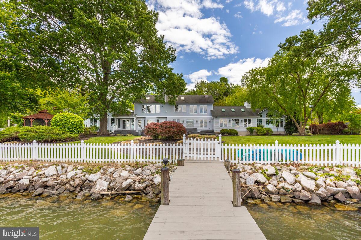Introducing a remarkable waterfront property that boasts breathtaking and unobstructed views of South Creek on the West River. This contemporary home features a well-designed layout with five bedrooms and four and a half bathrooms. Spanning over 6000 square feet of fully remodeled living space, the first floor offers abundant opportunities for enjoyment.

Step into the Great Room, where a stunning stone fireplace takes center stage, creating a captivating focal point. The modern open Kitchen, elegant Dining Room, and a convenient half bath complete the main level. With high glass windows adorning the first floor, natural light floods the space, showcasing the dramatic views that surround you. Additionally, a privately located Primary Bedroom and full bath adds a touch of seclusion.

The backyard beckons you to explore your way to the Chesapeake Bay, easily accessible via the 170' plus pier. This impressive pier boasts two full-size boat lifts and two jet ski lifts, catering to your watercraft needs. A sprawling lawn, adorned with majestic oak trees, provides a tranquil retreat during Maryland's balmy nights while offering undisturbed views of the River's beauty. The fully fenced lawn encompasses 240' of waterfront, featuring a bulkhead and ample space for outdoor fun and entertainment. Unwind on the expansive Trex Deck or retreat to the screened Gazebo, relishing the peaceful evenings by the Chesapeake Bay. To further enhance the serenity, nearby Osprey nests add to the harmonious ambiance this home exudes.

Upstairs, privacy is ensured with two separate stairways leading to the four bedrooms. One of these bedrooms can serve as a second primary suite, offering flexibility in accommodations. A second-floor living space on one end provides a generous area for taking in stunning sunsets and indulging in day-long, relaxing bay views.

1258 West River Road is thoughtfully designed with spacious rooms, an open and airy floor plan, and appealing upgrades. Its prime location on a point ensures unparalleled vistas and refreshing breezes, creating the ideal setting for a Chesapeake Bay lifestyle. Whether you seek a cozy retreat, family gatherings, or large-scale entertainment, this home caters to your every need.