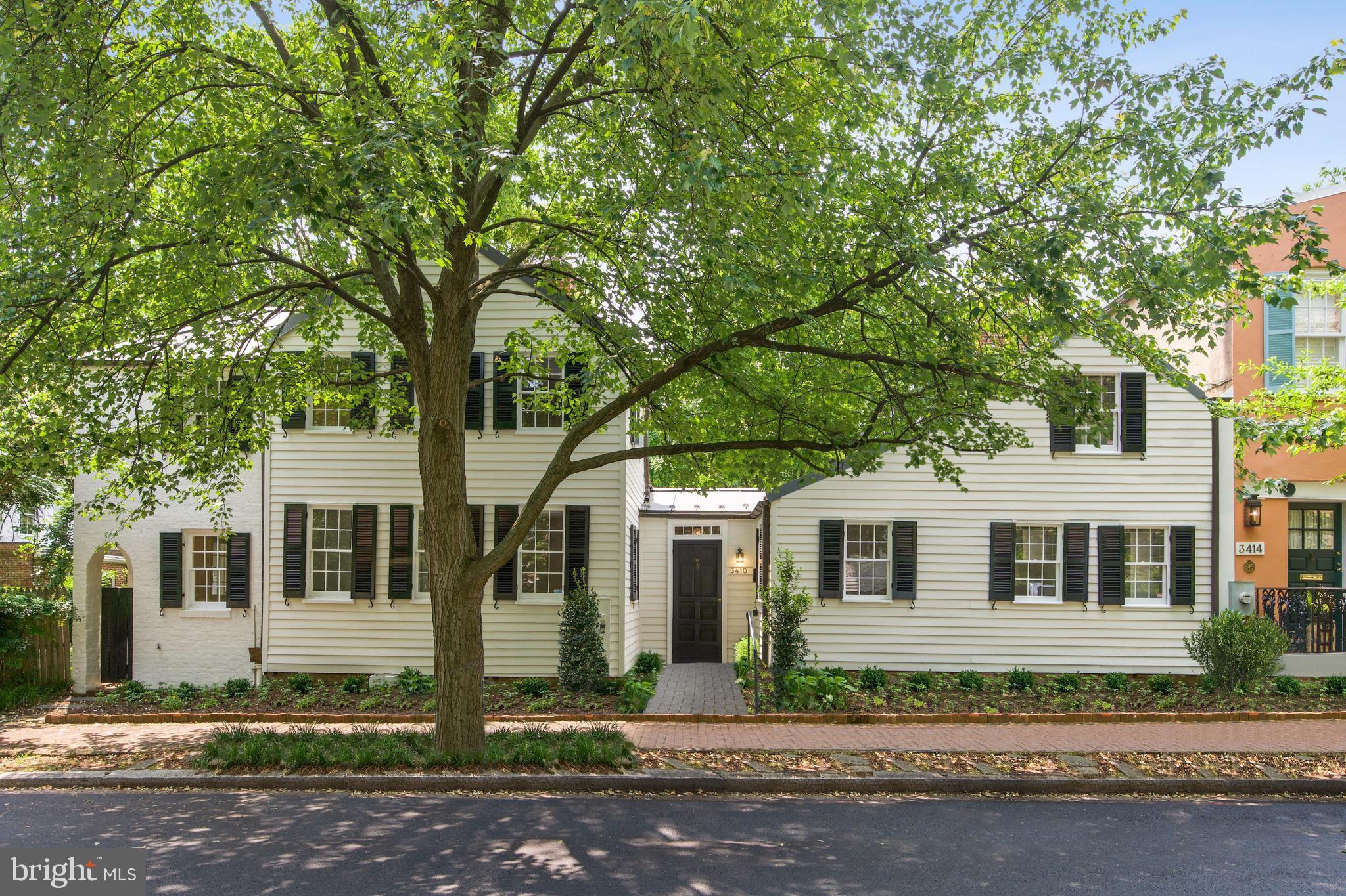 This delightful property, a Nantucket-style farmhouse in the middle of the city, is the very definition of timeless charm. With its wide-plank pine flooring, three fireplaces, and three full bathrooms it was constructed in the 1840s as two distinct homes. The original and classic houses were later merged into a seamless, expansive house and garden in the 1920s by renowned architects Horace Peaslee and Rose Greeley (See Virtual Tour for a short history of the property). The rear of the home is configured in a "U" shape, effectively bringing the outdoors inside, with all main level living areas providing access to the large brick and fieldstone surrounded private garden and terraced patio. 

The main floor contains the primary suite, and a second bedroom, while the upper-level features three additional bedrooms. The living room and dining room have cathedral ceilings, and there is a library with a wet bar and full bathroom currently used as a home office/study. The St Charles kitchen is a notable feature and the new kitchen and first floor bathroom flooring reflect the classic Georgetown style.  3410 Volta Place is located steps away from the Visitation School, Georgetown University, and the ballfields, tennis courts, and swimming facilities of Volta Park.  Bonus—you'll love the “secret” door overlooking the living room!

Show By Appointment Only