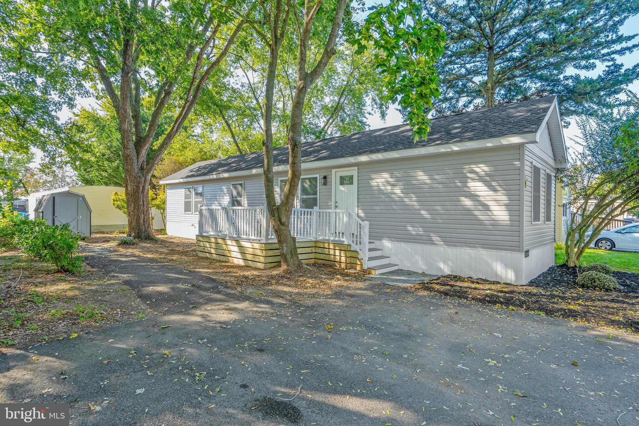 NEW PRICE!! Welcome to this beautifully remodeled in 2025 manufactured home in the sought-after Whispering Pines community—redone down to the sheetrock and subflooring! With upgrades including a new roof, windows, deck & railings, HVAC, electrical, plumbing, appliances, and more, this 2-bedroom, 2-bath home offers the comfort and feel of a brand-new build.
Step onto the brand-new front deck, surrounded by mature trees, and enter an open-concept living space featuring luxury vinyl plank flooring throughout. The light-filled living room flows into a spacious dining area and a modern kitchen, complete with all new white cabinetry, tile-accented walls, recessed lighting, stainless steel appliances, and a window above the double sink that looks out onto the peaceful yard.
The primary bedroom includes a generous walk-in closet and a private ensuite bathroom with a step-in shower, new vanity, and all new fixtures. A second bedroom and fully remodeled bath offer comfort and flexibility for guests or home office use.
Outside, enjoy the privacy and shade of mature trees, plus a storage shed for your beach gear and bikes. Whispering Pines offers a community pool, playground, basketball court, and covered picnic area—everything you need for an active lifestyle.
Located just 10 minutes from downtown Lewes and its beaches, boating, and outdoor recreation, with easy access to Route 1, shopping outlets, dining, and Rehoboth Beach just minutes away. Conveniently located near schools, grocery, pharmacy, and hospital/medical care, this is your move-in ready coastal retreat!