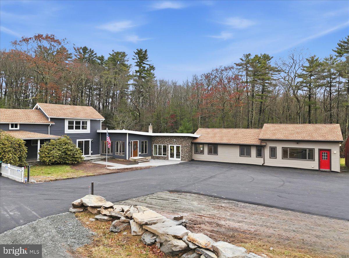 OPEN HOUSE!!! Saturday 12/20 10a-2p! Welcome to your completely remodeled, multi-wing Milford retreat, where comfort meets flexibility. Set on 1.62 acres bordering state game lands, this 6-bedroom, 4-bath home has been transformed from top to bottom so you can move in with ease and start your plan B almost immediately. Local zoning supports accessory living, transient lodging, and home-based business use. With a luxurious kitchen in the main house, a practical kitchenette, and two laundry rooms, the layout is ideal for a mother-daughter setup, multi-generational living, or a primary residence with multiple income-producing options. Every renovation was completed with integrity and attention to detail: a new state-of-the-art septic system servicing the entire property, new roof and siding, a newly paved driveway with ample parking, brand-new water heater, generators and a beautiful new connector room that unites the home's wings seamlessly. Every appliance, fixture, and finish - from flooring and carpeting to lighting and paint is new. Every system was upgraded or replaced; not a stone was left unturned. Step into the original farmhouse and you'll feel the charm of history preserved: the original stone floor, exposed beams, and a classic stone hearth fully inspected and ready for cozy fires. Upstairs are two private bedrooms, a full bath, and generous storage the perfect tucked-away quarters for Bed-and-Breakfast guests or friends visiting the Poconos for the weekend. The main kitchen is a true centerpiece: white shaker cabinetry, granite countertops, mosaic tile backsplash, double ovens, gas range, LG energy-efficient appliances, and a walk-in pantry. Sliding doors open to a front stone patio, while beamed ceilings and layered lighting make this space the bright, welcoming heart of the home. Off the kitchen, a flexible room with high ceilings, its own bath, and laundry area can serve as a home office, classroom, studio, or guest suite. Beyond that, the massive family room features a brand-new pellet-burning stove, walls of windows, and a vaulted ceiling. The large primary bedroom with an ensuite bath has its own soaking tub overlooking the backyard, a shower, a double vanity, and custom built-ins.
The new connector wing flows effortlessly into the second living area, complete with its own split HVAC unit for efficiency and comfort. This bright, open space serves beautifully as a guest entrance, office, or sitting room for the three attached guest bedrooms, fourth bath, compact kitchenette with dishwasher and refrigerator, and separate laundry.
Outside, the property unfolds into a landscaped yard overlooking a peaceful woodland stream - private, natural, and perfect for gatherings. Multiple patios invite outdoor dining or future event hosting. The detached pole barn features a concrete floor, is fully wired for electricity, and offers flexible use as a workshop, garage, or storage for tools and toys.
While perfect as a private residence, this property's approved zoning for Lodging/Transient use (LOD) and ideal location, only minutes from the I-84, Milford Center, New York and New Jersey, make it far more than a home; it's an opportunity for a whole new life! Live here full-time, host guests, operate a boutique inn, or simply generate income on your terms. If you're ready for a life-changing switch one that offers everyday comfort and built-in potential welcome home. Live beautifully. Earn quietly. Expand intentionally.