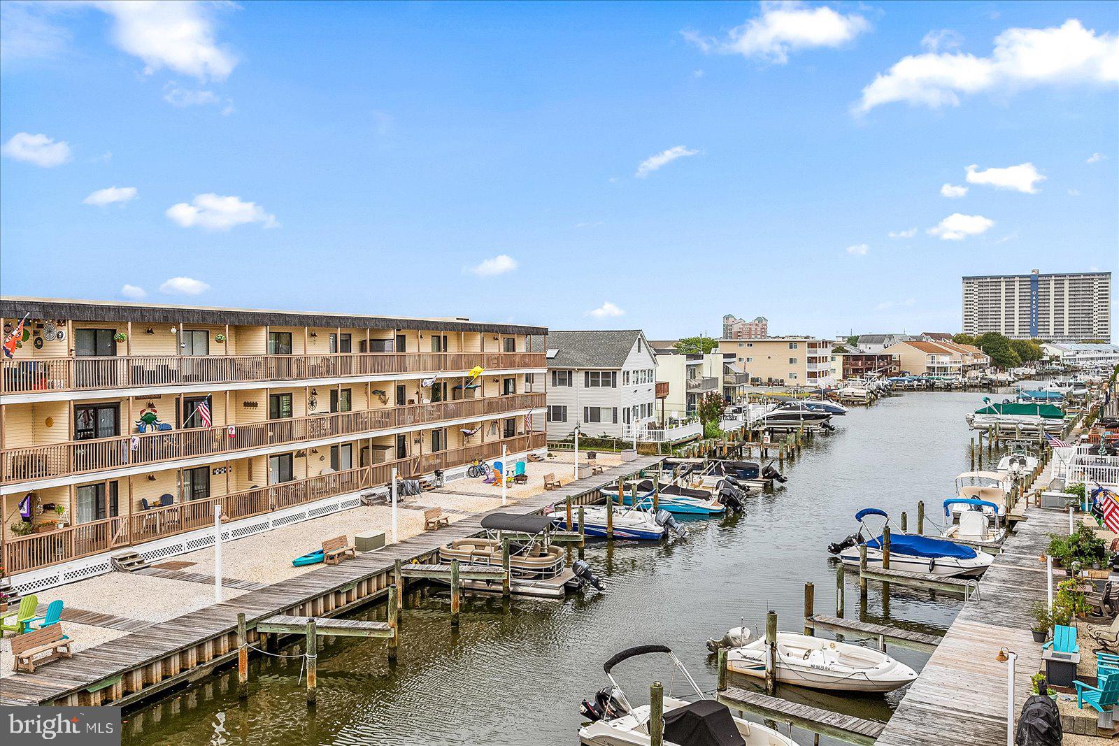 Your perfect beach escape is finally here. Welcome to Windward Landing South, Unit 204—a second-floor, 2-bedroom, 2-bath condo that checks every box for the coastal lifestyle. Tucked away on the bayside yet just a short distance to the beach, this condo offers the best of both worlds. The bright, open living room flows effortlessly onto a spacious balcony overlooking the canal—an ideal spot to start your mornings or wind down after a day spent at the beach or relaxing by the outdoor pool. Designed for easy entertaining, the open kitchen features a breakfast bar and connects seamlessly to the dining area, offering plenty of space to gather with family and friends. Both bedrooms are spacious, with the primary suite featuring balcony access and an upgraded ensuite bath for added comfort. Boaters, this one’s for you—boat slips are available for just $100 per year (as available), making it easy to enjoy endless days on the water. Each unit also includes its own private storage/utility closet conveniently located just across the hall. The location is hard to beat, with quick access to Ocean City favorites like the Greene Turtle, Gold Coast Mall, Starbucks, Tail Chasers, and so many other local favorites. Whether you’re going out for dinner, grabbing coffee, or heading to the beach, everything you love is right nearby. If you’re dreaming of your own slice of beach life, this condo delivers it all. Come see why Windward Landing South 204 feels like vacation the moment you walk in.