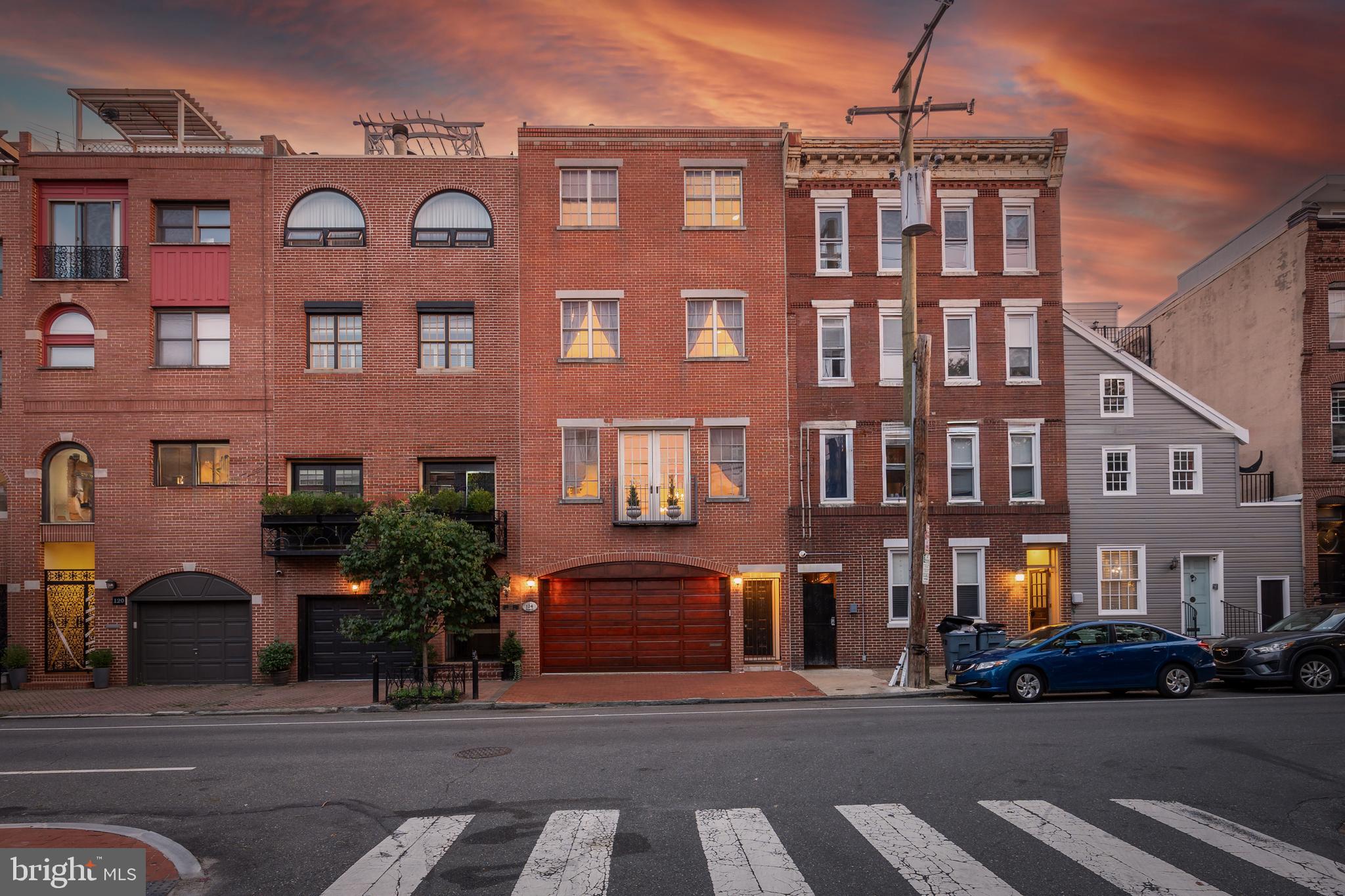 If you're seeking a distinctive residence where craftsmanship meets sophistication and location meets lifestyle - this is the home for you! Welcome to this remarkable 5 bedroom 5 bath masterpiece in the heart of historic Queen Village! Custom built in 2003 and thoughtfully designed, this almost 5,000 sqft blends luxury, high end finishes AND a superb location. Set on a serene tree lined block just steps from HeadHouse Square, newly renovated Penn's Landing and a wonderful mix of walkable restaurants (Zahav, Cry Baby Pasta) boutiques, and amenities. 
Enter the home through the 2 car garage and the grand foyer welcomes you in, featuring premium moldings, soaring ceilings, a custom bar/ entertainment area, and custom Schonbek chandeliers. The back English brick patio offers a lux space for entertaining, gardening, and cooking. Take the custom oversized elevator to the second floor where you will find the chef's kitchen built for all your needs. The oversized island, high end appliances (Thermador/Monogram), dual dishwashers, plus generous cabinet space will meet the needs of entertaining guests or a growing family. off the kitchen, an elegant formal dining room with French pocket doors sets the tone for upscale dinner parties. The formal living room at the front of the home features a beautiful gas fireplace and a Juliet balcony offering open city views. 
The primary bedroom suite occupies its own floor, complete with another gas fireplace, dual walk in closets, laundry room, and spa style bathroom with a soaking tub and glass enclosed shower. The fourth floor features your guest bedrooms and additional bathrooms so everyone has their own space. The crowning feature is the roof deck offering panoramic views of the city skyline and Delaware river, perfect for morning coffee or evening cocktails. The fully finished basement is truly a canvas for whatever you can think of, whether you prefer a home office, a custom gym, extra storage space, OR all of above, there's no shortage of space!
In additional to all the incredible features inside, this home earned a walk score of 95! With the renovations to Front St and enclosing of I-95 the walkability will only increase!
Enjoy the best of city living while being tucked away in one of the most desirable neighborhoods in Philadelphia. Don't miss then opportunity to make 124 Bainbridge your new address.