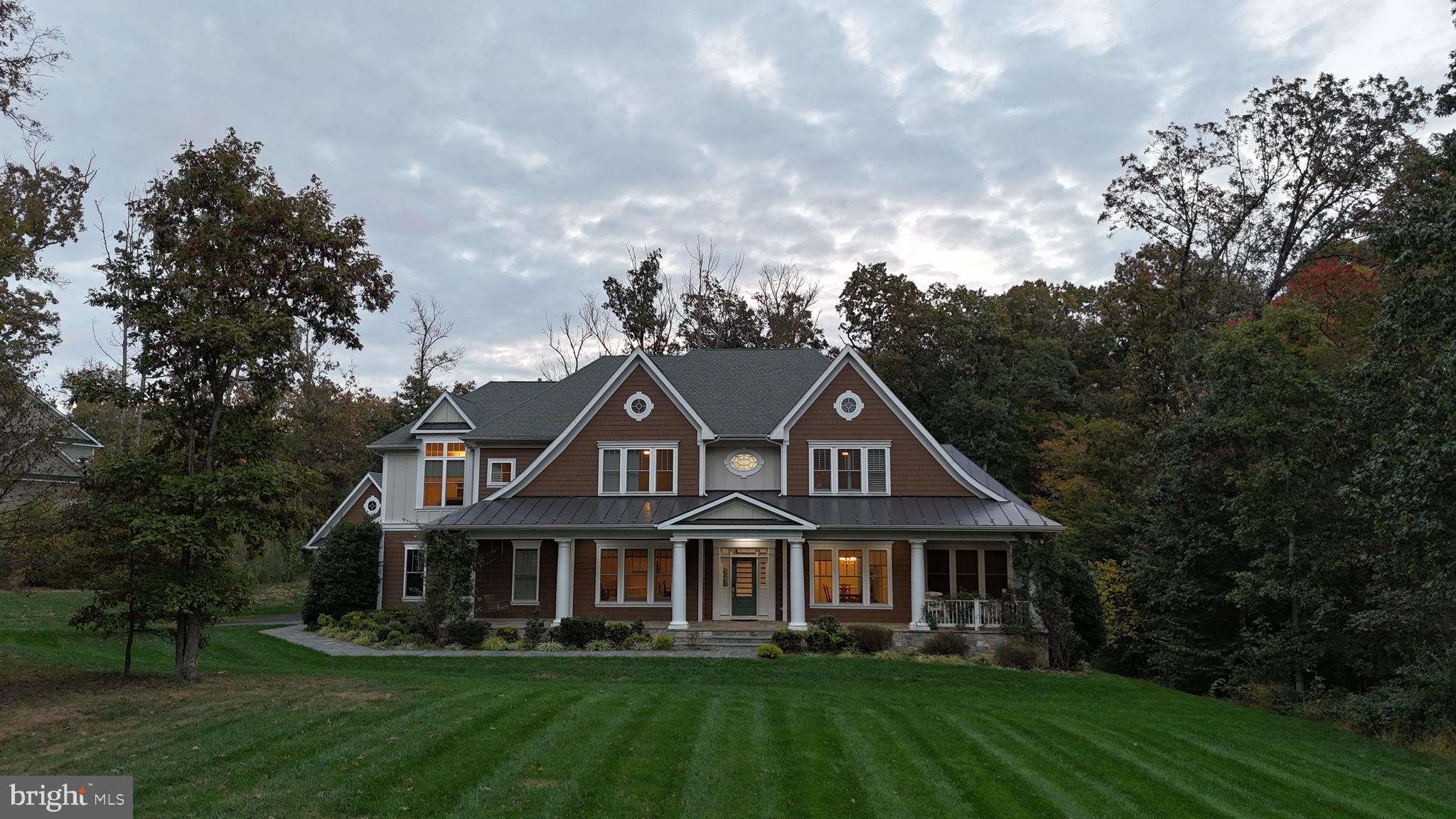 ***Catered Open House Friday (4-6pm), Saturday (1-3pm), and Sunday (1-3pm)! ***

Spoil yourself with more privacy.

Welcome to your private retreat tucked deep into the woods of Fairfax. Surrounded by five acres of mature hardwoods and bordered by preserved conservation land, this one-of-a-kind estate in Fox Chapel Estates delivers the quiet, the privacy, and the presence you simply can’t fake.

Built in 2017 and immaculately maintained since, this 6-bedroom, 6.5-bath home blends traditional Virginia architecture with modern upgrades and a floor plan that lives as well as it impresses. The long driveway winds through towering trees before opening to a beautifully landscaped entrance. A 200-year-old oak anchors the property, and the full wraparound porch sets the tone for relaxed, gracious living.

Inside, 7-inch cherry hardwood floors lead you through formal and casual spaces designed for entertaining and everyday comfort. The main level features a sunroom, dining room, private office, and a coffered-ceiling family room with a granite-surround gas fireplace. A guest suite with its own full bath provides privacy and convenience, and there's also a well-placed half bath for everyday use.

The kitchen was made for more than cooking. With upgraded Sierra Vista glazed cabinetry, granite countertops, a gas cooktop, GE Monogram stainless appliances, and a layout that flows into the breakfast area and family room, it invites connection. Whether you're prepping for a party or enjoying a quiet morning, it works with you, not against you.

Upstairs, you'll find four generously sized bedrooms, each with its own full bathroom. The spacious primary suite offers a spa-inspired retreat, while the layout ensures privacy for everyone—no shared baths, no crowded corners, just calm and comfort. A large laundry room on the bedroom level keeps everyday life running smoothly, right where you need it.

The lower level is a full extension of the home, not an afterthought. A large recreation space opens to the backyard through double walk-up doors. There’s a sixth bedroom and a full bath on this level, along with a music room behind French doors, a finished recreation room with wood-look tile, and a bonus room currently used as a playroom. Whether you need a media room, guest suite, studio space, or all of the above, this level delivers unmatched flexibility.

Outside, the property has been thoughtfully enhanced with low-maintenance hardscaping, a pergola covered in Japanese Wisteria, heirloom climbing roses, and a firepit-ready backyard surrounded by pure nature. An invisible dog fence encloses two acres for safe roaming, and a 2,900-square-foot privacy and landscaping easement from the adjacent lot adds a lasting buffer against future development.

The 3-car attached garage and 2-car detached garage offer over 600 square feet of enclosed parking and storage. Whether you need a workshop, garden station, or just room for the extras, it's all here. The Fox Chapel Estates HOA covers trash pickup, snow removal, and common-area landscaping, so the surroundings stay as polished as the home itself.

System updates include a whole-home water filtration system, water softener, generator, battery backup sump pump, and dual-zone HVAC. The roof, windows, and mechanicals remain in excellent condition since construction in 2017. Utilities include NOVEC electric, Washington Gas, a private well, and a conventional six-bedroom septic system.

Even though you're wrapped in nature, you're never far from convenience. I-66 is five minutes away, the VRE is 10, and the Metro is just 20. Groceries, big-box stores, and dining are all nearby, but far enough to preserve the peaceful energy that defines this home.

If you’ve been waiting for something that offers seclusion without compromise, welcome home. This is the kind of place that meets you where you are and gives you room to grow.