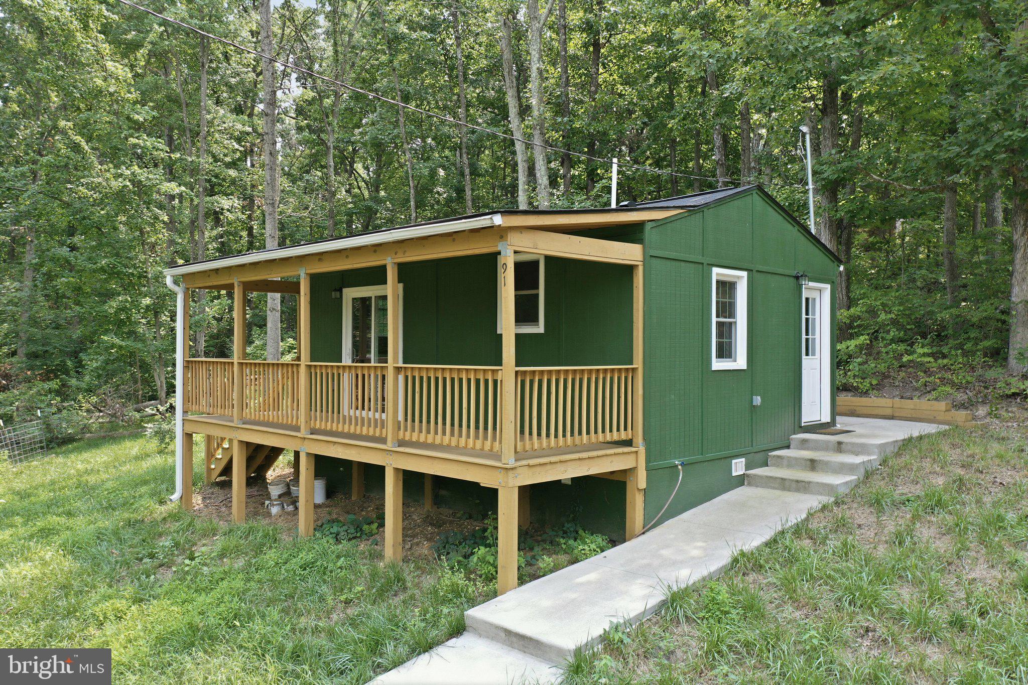 Charming one-acre retreat just minutes from downtown Front Royal! This 2022-built home offers 408 sq ft of thoughtfully designed living space — ideal as a weekend getaway, hunting cabin, or low-maintenance full-time residence for someone who wants privacy without the upkeep. Relax on the spacious covered front porch and take in Skyline views or unwind on the wraparound back patio surrounded by nature. Cozy up by the pellet stove on cool Shenandoah Valley evenings, then spend warmer months exploring the full acre — plenty of room for pets, gardening, or outdoor gear. New construction means low maintenance and modern systems, all just a short drive to Front Royal shopping, dining, and Skyline Drive access. Immediate occupancy available. A rare opportunity to own a slice of the Blue Ridge foothills at an accessible price point. Won’t last!