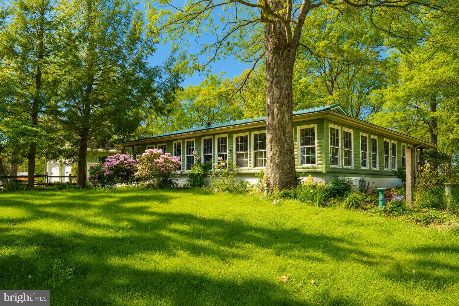 Discover the charm and comfort of this beautifully maintained manufactured home, nestled on a generous 2.07-acre lot. With a unique blend of rustic appeal and modern convenience, this property is perfect for those seeking a serene retreat without sacrificing accessibility. Step inside to find a warm and inviting interior with carpeting and laminate flooring that flows seamlessly throughout. The galley kitchen is equipped for all your needs and convenience. This home boasts two bedrooms, including an entry-level bedroom that offers easy access and comfort, well-appointed bathroom and a wraparound sunroom that adds even more living space and comfort to this home. Ceiling fans throughout the home provide a refreshing breeze, enhancing your comfort year-round. Step outside to your private oasis, where a charming deck invites you to relax and soak in the tranquility of your surroundings. The property also features a gazebo, perfect for outdoor gatherings or quiet moments of reflection. With a detached garage that accommodates up to four vehicles, additional storage including a workshop area, you'll have plenty of space for all your hobbies and equipment. Also included is a large pole building for extra storage or workshop. An additional oversized shed beside the pole building offer another “get away space” to enjoy more quiet time. And if that’s not enough, there is an additional lot included with the sale. This home is not just a place to live; it's a lifestyle choice that offers peace, privacy, and plenty of room to grow. Whether you're looking for a weekend getaway or a permanent residence, this property provides the perfect backdrop for your next chapter. Embrace the opportunity to create lasting memories in a space that truly feels like home. Don't miss out on this offering-schedule your private tour today and experience the potential that awaits!