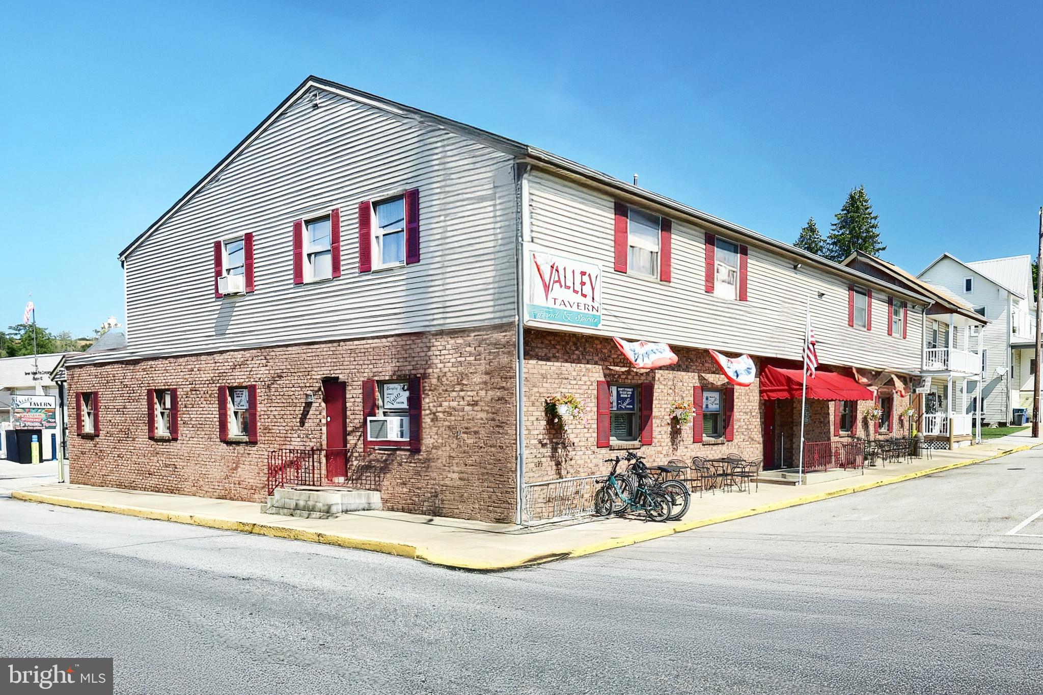 Step into a piece of York County history with The Valley Tavern. This iconic bar & restaurant has been a community cornerstone since 1875, originally opened by Daniel Henry as The National Hotel. 
After a devastating fire in 1985, the building was reborn, yet continues to preserve its storied legacy. 

What Makes It Special

Dual Atmosphere: One side serves as a lively bar, the other as a full-restaurant known particularly for its crab legs, broiled crab cakes, and legendary broasted chicken. Perfect whether guests want a casual drink, dinner, or both. 

Carry-Out & Convenience Features:
• A six-pack walk-out service for those wanting beer to go. 
• A drive-up window so customers can pick up food or drinks without leaving their vehicles. 

Trailside Destination: Situated directly on the York County Heritage Rail Trail, The Valley Tavern is a natural stop for walkers, hikers, and bikers. It benefits from consistent foot- and trail-traffic. 

Mixed-Use Potential: Two long-term apartments upstairs plus a large office space.  The office could be converted into an additional residential unit for extra income. 

Outbuilding & Storage: There is a large detached garage offering significant additional storage capacity especially valuable for a business with food/beverage inventory and seasonal equipment.

Historical & Local Significance

Originated in 1875 as The National Hotel. Tavern licenses dating back to the early 1900s are still proudly displayed. 

The building has survived storm damage (including from Hurricane Agnes in 1972) and was destroyed by fire under the Lippy family’s ownership in 1985; fully rebuilt since that event. 

While the exact date the name “The Valley Tavern” replaced “The National Hotel” isn’t clearly documented on the sources we reviewed, it likely transformed sometime in the mid-20th century under different ownership.

Financial & Business Strengths

The business has strong, growing revenues and profitability for the region. Year after year, sales have increased, driven in part by its location and loyal customer base. It draws traffic not just from locals but from trail-goers and visitors, giving it both consistent and seasonal demand.

Key Assets & Opportunity

Location & Visibility: Trail-side and on a main street of Seven Valleys, high visibility, easy access.

Dual income streams: Restaurant/bar income + rental income from upstairs residences/offices.

Room for growth: The upstairs office could expand income by being converted into housing; enhancing marketing (especially trail & outdoor community) could increase off-peak traffic.

Amenities: Detached garage/storage, carry-out window, six-pack walk-out, separate bar & restaurant areas.

In Summary

The Valley Tavern is more than just a bar & restaurant. It’s a landmark, a business with deep roots in York County history, a prime location serving both locals & trail traffic, multiple income sources, and strong sales performance. For someone seeking a turn-key hospitality business with charm, history, and upside, this is a rare find. Sale includes property, business, liquor license and all equipment and inventory.