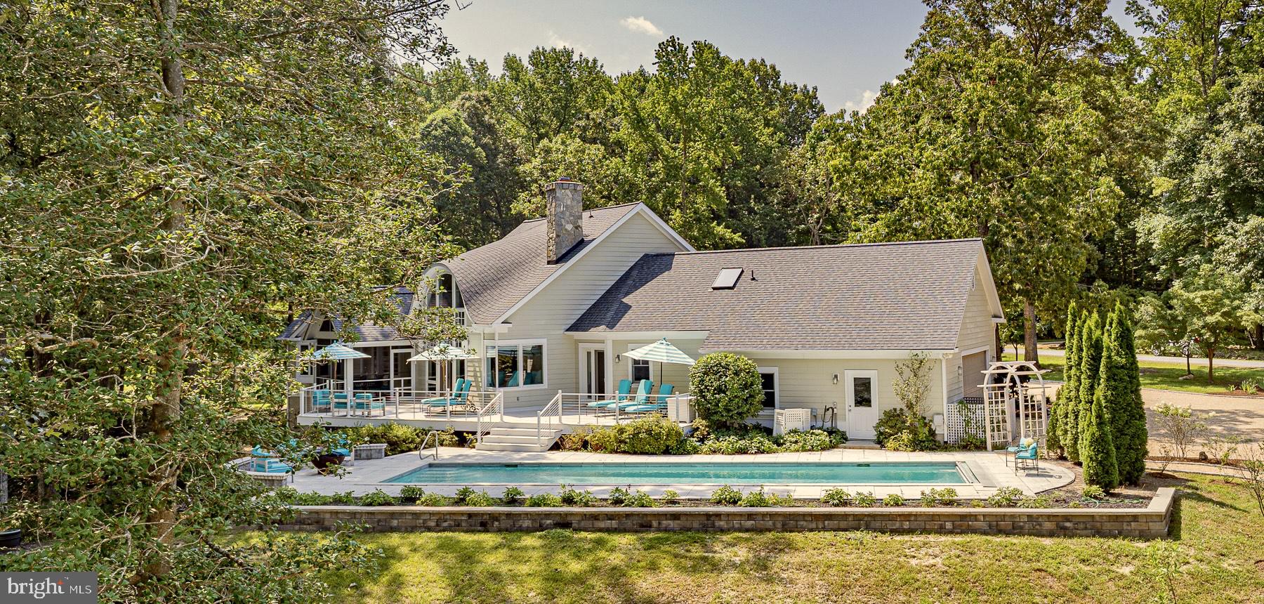 This premier single family or multi-family compound boasts the quintessential river feel with a modern updated design. With a 3800 sq ft main home and a 1770 sq ft guest house (each with its own utilities/systems), this is an ideal property for several generations or multiple owners. The 2+ acre property with 231 feet of Carter’s Creek waterfrontage and a gently sloping shoreline out of the flood zone boasts an architecturally stunning main home with breathtaking water views and a custom guest house perched on a landscaped knoll overlooking the creek. This property features exceptional outdoor living space to include a waterside, heated 48’ lap pool, screened porches and decks off both the main home and guest house and dock to 5’ MLW with 3 slips, 2 lifts and a kayak launch.  The main home offers open living space with vaulted ceiling, designer fixtures, a floor to ceiling stone fireplace and a kitchen with premium appliances and fully equipped butler’s pantry.  The primary suite includes a waterside bedroom, his/hers full baths and dual closets, a sunny office with space for an art studio or reading chair and a separate dressing area. The main level also includes a bedroom with huge views and an ensuite bath with zero-entry tile shower, a powder room and a 2 car attached garage. The walk out lower level features a family room with wet bar, bedroom, full bath, sauna, wine closet and covered waterside patio.  The custom modern guest house features a 2nd floor open-plan living space with oversized kitchen island, bar counter with wine fridge, ensuite bedroom and half bath with laundry. Two first floor bedrooms with hall bath, attached garage with electric charging station and both car and golf cart parking and the third floor office make this home perfectly sized for extra family and friends.   This property is everything a luxury river home can be, replacing the sites and sounds of city life with the sparkle of sunshine on water and the hum of a boat motor crossing the creek. Only 1 hour and 20 minutes from Richmond, this luxury family compound is filled with natural light and plenty of entertaining spaces. With restaurants and grocery store choices within minutes, this location has it all.