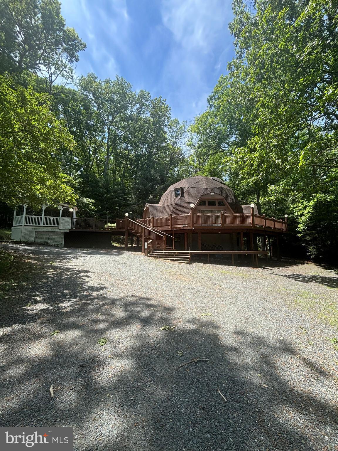 Nestled on 2.3 private, wooded acres, this distinctive dome-style residence offers a rare blend of architectural character, natural beauty, and spacious living. Surrounded by mature trees and tranquil views, the home provides a peaceful retreat while offering ample space for entertaining and everyday living.

Inside, you'll find 4 generously sized bedrooms and 3 full bathrooms, thoughtfully designed to accommodate family and guests alike. Separate in law apartment in basement houses one of the full baths, a kitchen, bedroom and additional laundry! The unique architecture creates warm, inviting spaces filled with charm and natural light. Expansive outdoor decking wraps around the home, providing the perfect setting for morning coffee, outdoor gatherings, or simply enjoying the serene surroundings.

Whether you're seeking a private getaway, a full-time residence, or a one-of-a-kind property unlike anything else on the market, this exceptional home delivers privacy, space, and timeless appeal in a beautiful woodland setting.

This is an estate sale and being sold strictly as-is, no FHA or VA financing due to this property's uniqueness!