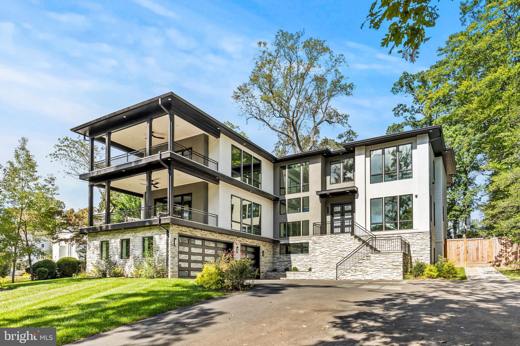 Contemporary residence within a mature McLean streetscape on a generous, tree framed lot. Positioned well back from the road, the home reads with the presence and composure of a newly delivered property, meticulously maintained, fully resolved, and immediately ready for occupancy. Built by Green Valley Custom Builders, every element reflects a level of care that leaves little to be desired, a rare offering that competes directly with new construction while avoiding its uncertainty, delays, and cost premiums.

More than 9,400 square feet spans three finished levels, organized around a dramatic two story great room with a full wall of glass overlooking the rear grounds. A gallery overlook connects the upper level, allowing formal and informal spaces to flow in comfortable proportion, with a sense of volume and light that feels both expansive and controlled.

The main kitchen anchors daily living and entertaining, featuring custom cabinetry, premium appliances, a large central island, wine bar, walk in pantry, and private catering kitchen. It is a layout designed not only for presentation, but for real use at scale.

The primary suite opens to a private terrace through walls of glass with automated shades. A sitting area with a private bar reinforces the sense of retreat, complemented by a spa bath with a freestanding tub, oversized shower, and heated floors. Every component is complete, refined, and functioning exactly as intended.

The lower level extends the home’s hospitality by offering a full bar, wine storage, fitness studio, theater room, and guest suite, providing flexibility for both everyday living and extended stays. A three car garage connects directly to built in storage and a dedicated dog wash. An elevator shaft is already framed for future installation, preserving long term adaptability without compromise.

Outdoor living includes a covered deck with a fireplace, integrated heaters, and a cooking area, with clear provision for a future pool and terrace within the fully fenced yard. The grounds are established, usable, and ready to be enjoyed immediately.

This is a home that presents with the clarity of a model residence, fully executed, carefully maintained, and offered at a level that compares favorably to recent new construction alternatives. For a buyer seeking confidence, immediacy, and long term value, the opportunity is straightforward.

Conveniently located near downtown McLean, the property offers privacy, scale, and direct access to Washington, D.C. and major commuter routes.