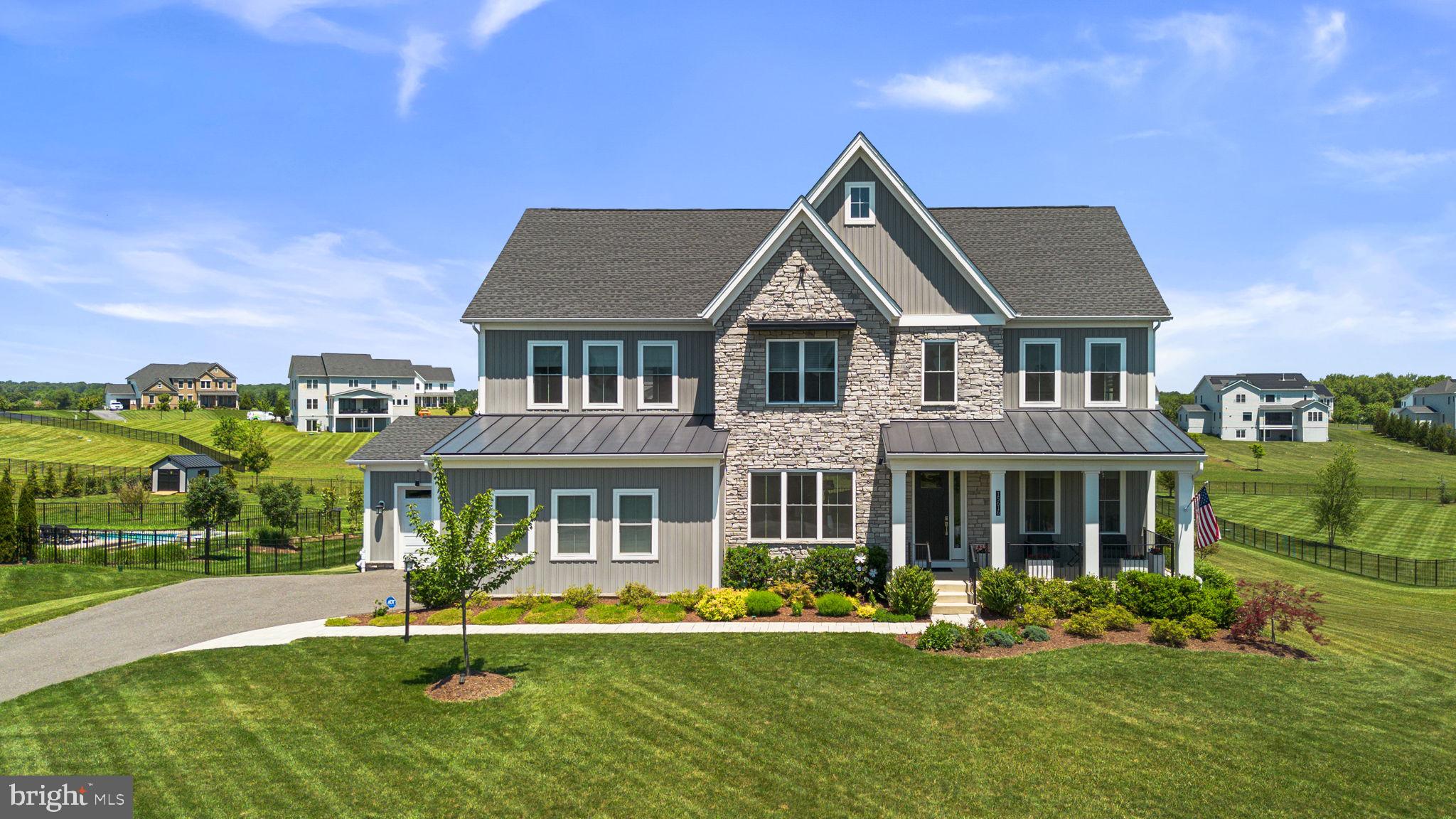 Experience refined luxury living with this exceptional estate residence nestled within the highly sought-after Linden Grove community. Perfectly positioned on a private 1.244-acre homesite, this meticulously maintained home offers an unparalleled blend of elegance, comfort, and functionality.
A welcoming covered front porch sets the tone for the impressive interior, where oversized windows fill the open-concept design with an abundance of natural light. At the heart of the home is a spectacular Chef's Kitchen featuring an expansive 12' x 5' island with full-depth cabinetry on both sides with seating for five that is beautifully lit by 3 gorgeous Hubbardton Forge pendant lights.  An oversized walk-in pantry completes this gourmet kitchen. Adjacent to the kitchen, a versatile flex room features granite countertops, a built-in desk, and ample upper and lower cabinetry with under-cabinet lighting, providing the perfect space for countertop appliances, additional prep area, and extra storage. A generous mudroom-style drop zone adds exceptional organization and convenience.
The open floorpan is ideal for entertaining. The dramatic great room is highlighted by 12-foot multi-panel stacking glass doors that seamlessly connect the interior to a luxurious screened porch complete with a stone-surround gas fireplace and ceiling fan. The porch leads to a spacious open deck which offers the perfect setting for outdoor dining and entertaining while overlooking the meticulously maintained flat backyard.
The thoughtfully designed second-floor layout features a spacious loft, a private guest suite with its own full bath, a Jack-and-Jill bath shared by Bedrooms 2 and 3, a conveniently located laundry room, three linen closets, and walk-in closets throughout. The expansive primary suite provides space for a sitting area and is complemented by a custom walk-in closet and an elegant spa-inspired bathroom, creating a true owner's retreat.
The fully finished lower level offers expansive living areas for fitness, relaxation and entertaining with a convenient walkout to the backyard. A covered patio with a weatherproof ceiling creates a smooth transition between indoor and outdoor living. The level also includes a tucked-away wine cellar, powder room and two generously sized storage rooms.
Additional luxury amenities include a propane powered generator, residential fire suppression system, raised garden beds with programmable irrigation, and a 3-car garage with epoxied floors.
Residents enjoy the award-winning Howard County School System and convenient access to nearby parks, trails, athletic fields, pickleball and basketball courts, playgrounds, library, and community center. Ideally located with easy access to Baltimore, Washington, D.C., Frederick, and major commuter routes.  This remarkable residence offers luxury living at its finest.
