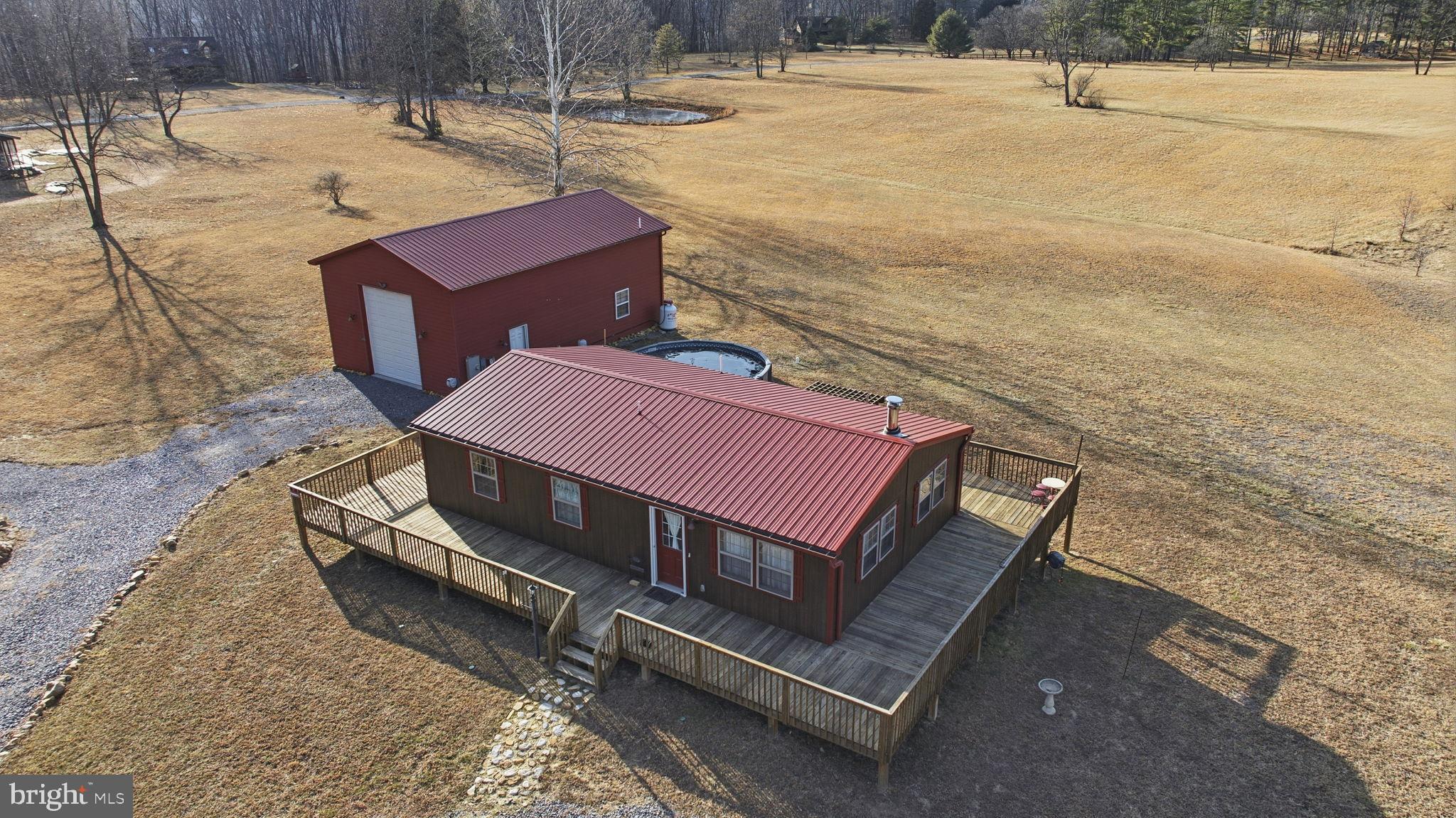 We have found what you are looking for, a home that is easy to maintain and a garage that will hold all your recreational needs. Take the time to look at this cozy cabin and move in before spring so you can enjoy the beautiful Cacapon River.  This home has sliding doors, hickory cabinets, stainless steel appliances, oh and an elevator in the home and in the garage. Elevator in the home will take you to the finished lower level where the floors are heated..  And there is more, wrap around deck leading to an above ground heated pool with the beautiful view from the back yard, and to the oversized garage with camper/ RV hookups, full bathroom and an extra room.  One more thing.. IT IS FOR SALE UNDER APPRAISED VALUE