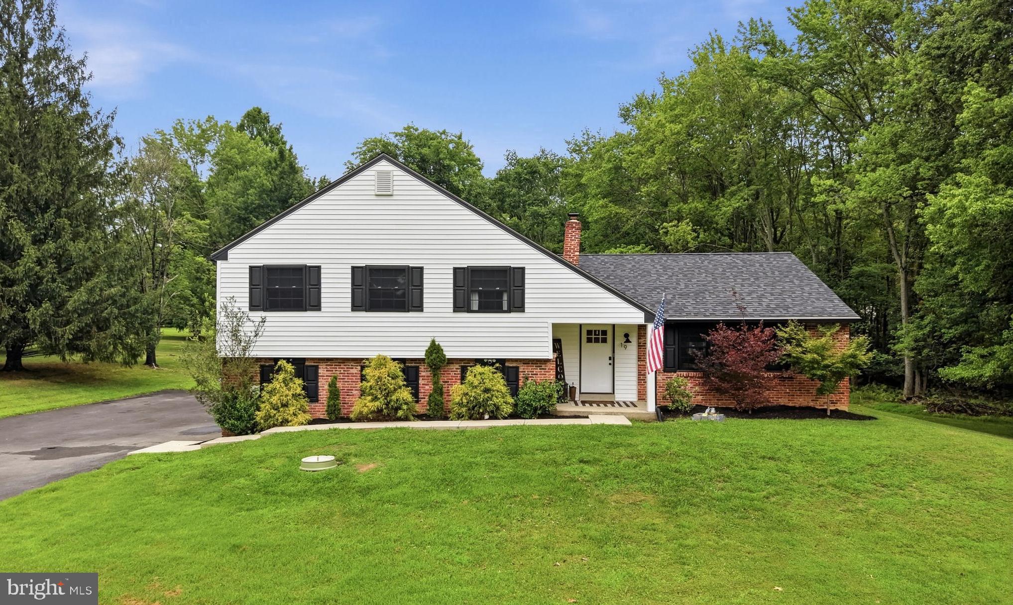 Welcome to 19 Elaine Drive, a newly redesigned, 4-bedroom, 2.5-bath, split-level home in the highly rated West Chester School District; nestled on over an acre of land, and surrounded by mature trees for added privacy, with an expanded & extended driveway. Enter into the open-floorplan main living area with a convenient coat closet, and engineered hardwood floors & recessed lighting that run throughout. A gas fireplace with a wood mantel serves as a focal point in the spacious living room that opens to the combination kitchen & dining room; offering plenty of space to gather. The incredible kitchen is a chef’s dream with gorgeous custom cabinetry, wood range hood, quartz countertops, 6-burner gas stove, drawer microwave, pull-out drawers with custom organizing attachments, a large center island offering additional prep space and seating for four, as well as a door leading to the back yard. Head down the stairs to find the family room with a cozy wood-burning fireplace and sliding doors leading to the back patio. Access to the two-car garage, laundry room, and half bath; both with new LVP flooring complete the lower level. Head upstairs to the primary bedroom with a built-in closet system and full bath ensuite with baroque tile floor, walk-in shower, and vanity for storage. Three additional bedrooms with ample closet space, and a full hall bath with linen closet, shower/tub combo & vanity complete the upper level. A finished walk-up attic, currently being used as a walk-in closet, offers additional flexible living space, perfect for a home office, guest space, or additional storage for all your seasonal items. Finally, make your way out to the partially covered back patio featuring a pergola, and lounge & BBQ areas. Whether you’re simply enjoying your morning coffee, relaxing after a long day, or entertaining family & friends, the private back yard offers endless opportunities. Amazing location, close to major roadways, parks, golf & country clubs, shopping centers, local dining, and everything Thornton has to offer. You won’t want to miss your chance to call this fantastic home your own, schedule your tour today!