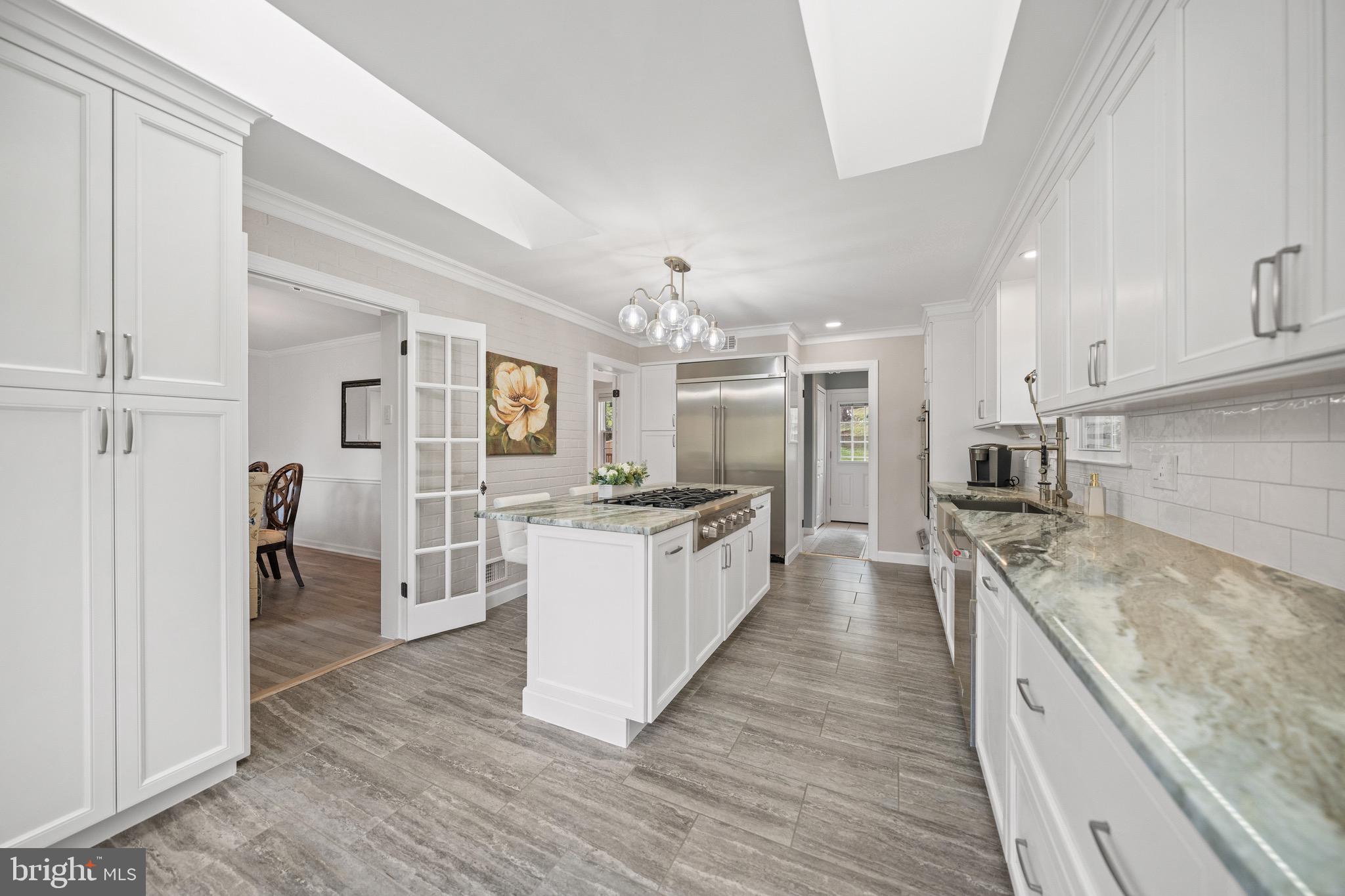 ASK ABOUT ASSUMING THE CURRENT 2.75% LOAN...MOVE IN READY!!! This updated all-brick colonial on a private half-acre delivers the finish of new construction with the soul of a home that has been painstakingly cared for. A honed marble foyer and curved wrought iron staircase set the tone: gracious formal rooms, hand-built architectural ceilings, ornamental millwork, and freshly refinished original white oak hardwood floors throughout.

To one side, a formal dining room. To the other, a sunlit step-down parlor beneath a custom ceiling dome and crystal chandelier. Ornamental crown molding, chair rail, and wainscoting carry from room to room. Every interior door is new solid wood, fitted with premium lever hardware. Every exterior door replaced, including a triple-pane steel French patio door with internal blinds.

The family room is anchored by a wood-burning fireplace with carved mantel over a marble-look hearth, painted brick, and an architectural coffered ceiling with dentil molding. French doors open to the renovated gourmet kitchen.

The kitchen, a complete gut renovation, centers on a 48-inch built-in stainless steel refrigerator/freezer, a six-burner professional gas rangetop on the island with telescopic downdraft, and a wall oven and microwave with warming drawer. Floor-to-ceiling custom cabinetry, American-made, solid wood, soft-close, with dual pantries, pull-out drawers, mixer lift, spice storage, and 36-inch double-deep drawers. Quartz countertops, 36-inch farmhouse sink with commercial faucet, 1-HP ultra-quiet disposal, reverse-osmosis filtration, instant hot water dispenser, and subway tile backsplash with adjustable LED lighting. Dual skylights and a bay window with custom built-in seating. Laundry room with custom countertop, mega-capacity front-load washer and dryer, built-in storage, and patio access.

Upstairs, the primary suite opens through double doors to ornamental crown and recessed lighting. The walk-in closet, a converted full bedroom, offers floor-to-ceiling built-in storage with integrated desk. A second walk-in closet. The en-suite spa shower: body jets, rainfall head, hand shower, and tiled bench within a glass enclosure. Cherry vanity with granite top and heated LED mirror.

Two additional bedrooms with hardwood floors and smart ceiling fans with decorative medallions. The hall bath: new porcelain top, faucet, LED mirror, and tile surround with ornamental diamond inlay. The powder room: deep navy walls above white wainscoting, marble-top vanity, and heated LED mirror.

The finished walkout lower level offers flexible living with premium luxury vinyl flooring, a dedicated room with closet, and a full bathroom built from scratch. Walk-in shower in marble-look porcelain floor to ceiling, dual niches with mosaic accent, frameless glass enclosure, fold-down bench, heated fan, and marble-top vanity. Cedar-lined closet and open recreation area.

Systems match the surfaces. A 2024 high-efficiency dual-fuel HVAC, heat pump with variable-speed blower paired with a 97% gas furnace, 10-year manufacturer warranty, whole-house humidification, air purification, and near-HEPA filtration. 200-amp electrical. Large 55-gallon water heater and stainless steel chimney liner. 

Smart thermostat, smart lighting, interconnected smoke detectors. Overhead lighting in every room: recessed fixtures, chandeliers, dimmers, and coordinated exterior package. Cellulose attic insulation with radiant barrier.

Outside, brand new driveway built from a premium base, extending to the rear patio, with one-year warranty, expansive, multi-level deck with built-in seating, curtained gazebo, and a fully fenced backyard. Brick paver patio, cedar playground, organic garden beds, stone retaining walls, arborvitae screening, and mature plantings on an organic lawn. Heated attached garage with premium insulated door.

Pet-free and scent-free. MOVE WITH CONFIDENCE! Premium home Warranty!