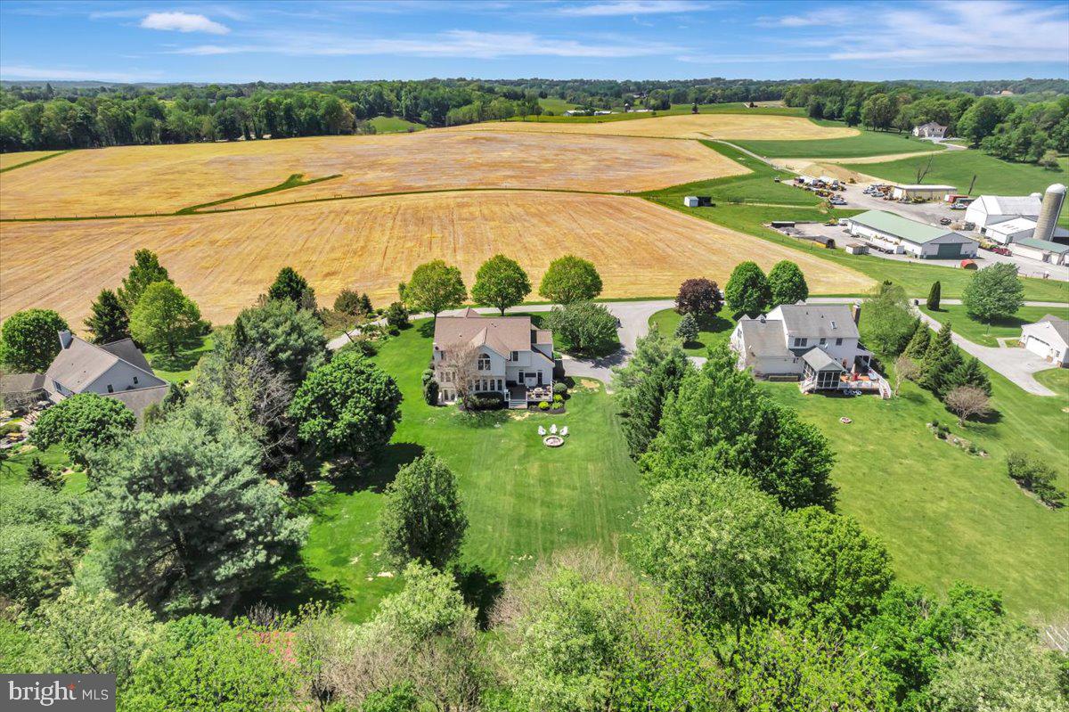 Welcome to a home that offers the best of both worlds, featuring a level, exceptionally spacious and open backyard ideal for entertaining, recreation, and everyday enjoyment, paired with a front yard that showcases sweeping farmland views and unforgettable sunsets. The backyard is a true outdoor entertaining dream, complete with a brick firepit, generous space for gatherings and outdoor activities, a peaceful natural backdrop, and room to further customize outdoor living. The thoughtfully landscaped and well maintained lawn enhances both settings, adding to the home’s impressive overall presentation. Tucked away on a quiet street serving only a handful of homes, this property offers a rare combination of privacy, open space, and a setting that provides a sense of added comfort and peace of mind. This exceptional 4 bedroom, 4 bath Colonial, built in 1997, features an elegant all brick front with a broad brick terrace style front porch and offers approximately 4,500 square feet of living space.

Step into a bright and welcoming interior highlighted by a grand two story foyer with elegant accent molding that sets an impressive tone from the moment you enter. The open concept layout features a spacious family room with a gas fireplace, creating a warm and inviting atmosphere, while the eat in kitchen overlooks both the family room and breakfast area. The kitchen includes granite countertops, a center island, abundant 42 inch maple cabinetry with soft close doors, tile backsplash, and stainless steel appliances. It flows into a sun filled breakfast room with numerous windows and direct access to a large maintenance free deck overlooking the private rear yard. A separate living room, formal dining room, convenient main level laundry, and powder room add both flexibility and functionality, while hardwood flooring extends throughout the entire upper level. The primary suite offers a private retreat with a sitting area, vaulted ceiling, and a spa inspired bath featuring a tiled glass shower, jetted soaking tub, and dual vanities. Secondary bedrooms are generously sized, including an expansive second bedroom with a vaulted ceiling and sitting area, and the updated hall bath includes ceramic tile flooring, a dual vanity, and quartz countertops.

The finished basement provides high ceilings, ample natural light, wide rear entry stairs, an open entertainment area, a full bath, and dedicated storage and utility rooms for added versatility. Additional features include architectural roof shingles installed in 2021 with a transferable warranty, a two car side load garage, a detached rear shed, zoned HVAC, a sump pump, and an owned 100 gallon propane tank servicing the fireplace. A one year home warranty is included for added peace of mind. Ideally located near shopping, dining, parks, and major commuter routes, this home offers easy access to I 795, I 695, Route 97, and Route 26, along with convenient proximity to Baltimore, Howard County, Frederick, and Hanover, Pennsylvania, making it a rare opportunity to enjoy space, comfort, and scenic beauty in a highly desirable setting. Experience all this exceptional property has to offer.  Some images may include virtual staging.