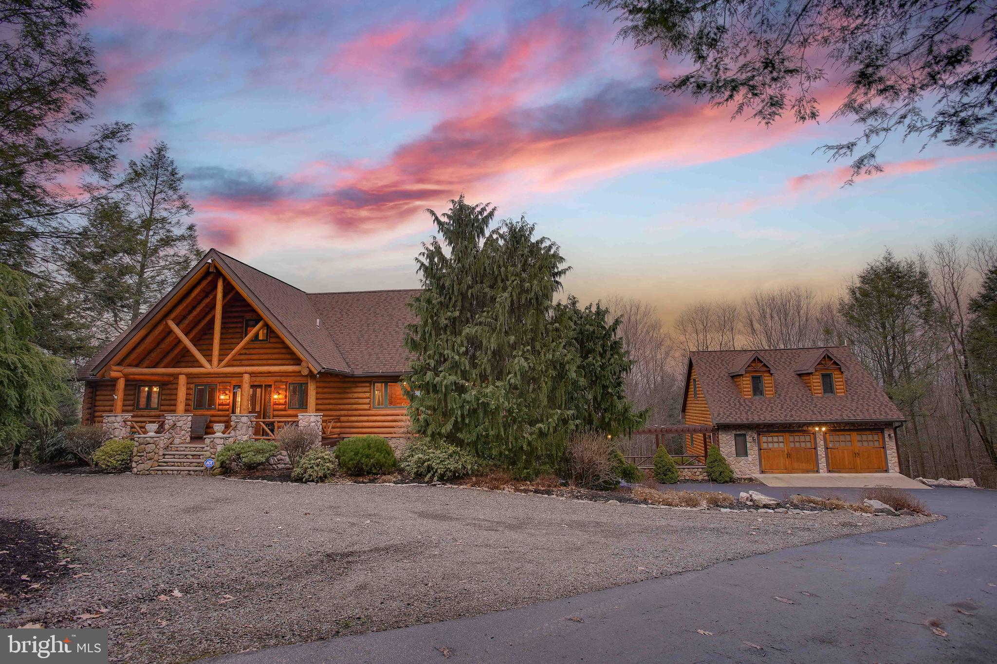Welcome to your own private paradise!
Discover this stunning log home in an extraordinary, private setting featuring an abundance of incredible living spaces inside and out. With expansive cathedral ceilings and huge windows showcasing many miles of unspoiled mountain views, a multi-level deck system providing loads of outdoor living spaces, the hot tub and heated pool, the property delights at every turn.
Stepping inside, you'll be drawn to the stunning great room, with a massive stone fireplace, vaulted ceilings and views for miles. The adjacent kitchen is a chef's delight, tastefully upgraded with custom cabinetry, and upgraded appliances and countertops. The dining room is a delightful place to enjoy meals with friends and family. On to the first floor primary suite, you'll love the spacious bath and walk in closet. The deck off this suite provides continued views and features the hot tub!
Upstairs you'll find two more delightful bedrooms, as well as another full bath and a kids nook for sleep or play. In the daylight lower level you'll find an additional living space with a second fireplace, as well as a full bath and an additional bedroom.
Moving to the detached garage, you'll find a delightful guest suite upstairs, and the partially finished garage set up as a game room/entertainment area. This space was previously rented as a vacation rental seperate from the main house and more recently the entire home has been used as such although it's currently not licensed for that use. Contents of the home are available for sale if desired.
The outdoor living is where this home really stands out, with the sparkling heated pool and multiple decks providing abundant space to entertain and enjoy, to stargaze and view sunsets. Paths meander around the home with abundant outdoor living areas designed to delight you.
All of this is before you even get to explore the 20 acres of delightfully private woodland, a hunter's paradise and lot of room to explore and enjoy nature. While largely steeper land, an ATV trail loops through the property and could easily be expanded on. Don’t miss your chance to own this exceptional retreat—schedule your visit today!