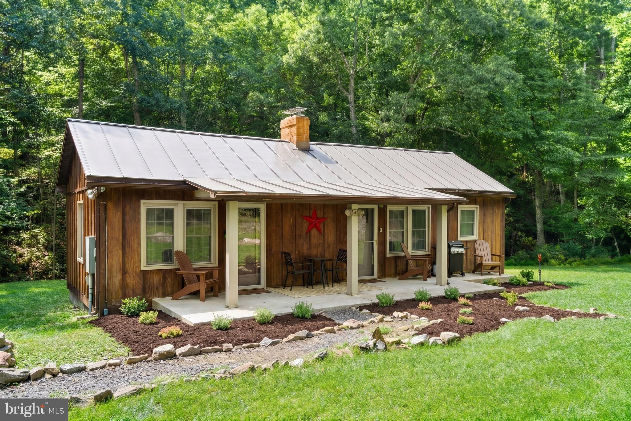 Peaceful, newly renovated & fully furnished 2-bedroom, 1-bath cabin situated on a private wooded acre with a year-round stream in the desirable Lost River area, just two hours from Washington, DC. Surrounded by nature with no other homes in sight, the property offers exceptional privacy while maintaining modern conveniences, including high-speed fiber internet and central heat. The inviting interior features an open living area, wood-burning stove, updated kitchen, and large windows overlooking the woods, while exterior amenities include a covered front porch, private hot tub, and creekside fire pit – perfect for relaxing and enjoying the peaceful setting year-round. Conveniently located near Lost River State Park, local shops, dining, arts, yoga, and outdoor recreation. As a vacation rental, the property has generated approximately $150,000 over the past three years ($38,000 in the past year) and can include an existing property manager and cleaner for a seamless transition. Hot tub  is available for purchase. See seller docs for detailed rental history and financials. $1,000 buyer credit available if you continue using the current property manager. No HOA. Brand new metal roof installed this spring.  Perfect primary home, mountain getaway, or investment property!