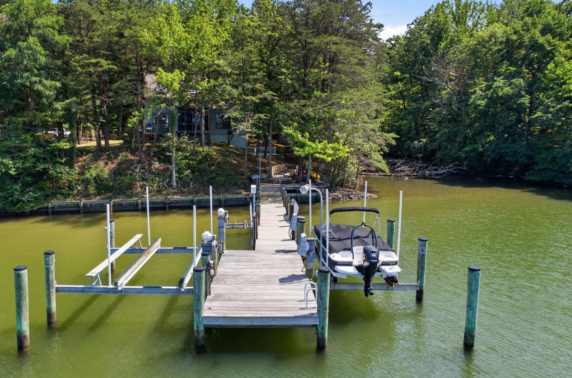 EXCITING POST AND BEAM HOME ON MILL CREEK IS READY FOR SUMMER! Includes a private pier with two boat lifts, extra shoreline decking for a shady lounge space, and a perfect spot for launching kayaks and SUPs. Arrive to this private and natural setting to a 1/2 acre waterfront site with a beautiful site elevation, great outdoor living spaces, cedar shake shingles and warm wood beamed interior. The home has geothermal heating-cooling, three finished levels, each with bedroom-full bath-adjacent living space. The main level space flows for entertaining, with a kitchen-dining-screened porch connection that is perfect for the ultimate waterfront experience.  Upper level loft in addition to full bath and bedroom with water views is a great hideaway. The lwoer level has a beautifully udpated bath and enarby bedroom, bunk area and recreation space, access to the pier. Mill Creek views are fantastic from most rooms, and the post and beam craftsmanship is stunning. A detached garage completes the offering and is perfect for storage of autos and also water toys in the winter months! It's all here and it's all ready now. Get your fishing poles and crab pots ready!
