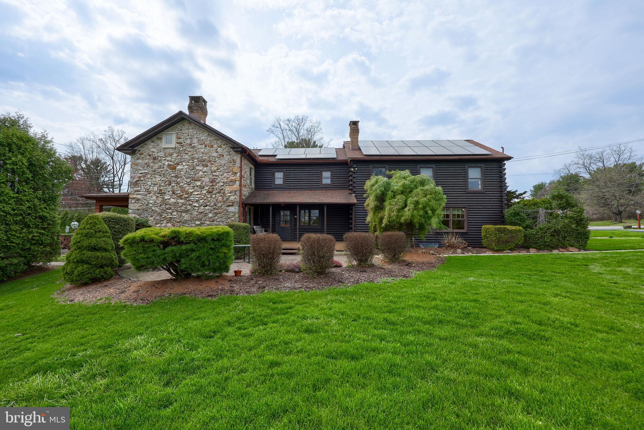 Settle your family into this extraordinary stone and log residence within the Oley school district. Spanning 3,224 square feet, the original part of the home was built in1860 and offers distinctive built-ins, deep window sills, and a walk-in fireplace anchoring the main family room. Picture yourself gathering with loved ones in a bright kitchen featuring an island, granite countertops, and 34 handle kitchen cabinets. The eat-in area connects to a spacious living room measuring 27 by 23 feet, which also houses a laundry room and one of three full bathrooms.
Upstairs, accessible via two staircases, you'll find five bedrooms and two full baths. There is an extra room perfect for use as an office or children's playroom. The master suite is large enough for a cozy sitting corner, with its bathroom boasting of a charming claw-foot bathtub. Throughout the second floor, numerous windows let in abundant natural light.
The basement stretches across the entire footprint of the house, and is divided into three sections. Entering from the stone portion of the house, reveals a well pump, a newer oil burner for secondary heating, an above-ground oil tank, and a 200-amp electrical panel. Most of the space serves as storage, while the central section is ideal for household projects and includes a unique spring cellar. At the rear of the basement, there's a finished 21-by-21-foot entertainment room, along with two closets containing HVAC units for the geothermal system. Outdoor access to the basement is provided by a Bilko door and another entry from the side porch.
Situated on a 1.62-acre lot, the home features a covered porch at the front and side, a generous brick patio, hot tub, and a two-car garage, with the well found beside the garage. Mature trees, shrubs, and plenty of open space offer opportunities for gardening and outdoor gatherings, making this home both inviting and functional.  
The Sellers installed geothermal heating and cooling along with solar panels, resulting in no electricity costs for nine months annually. The sale also includes a propane-powered Generac generator to guarantee uninterrupted utilities.