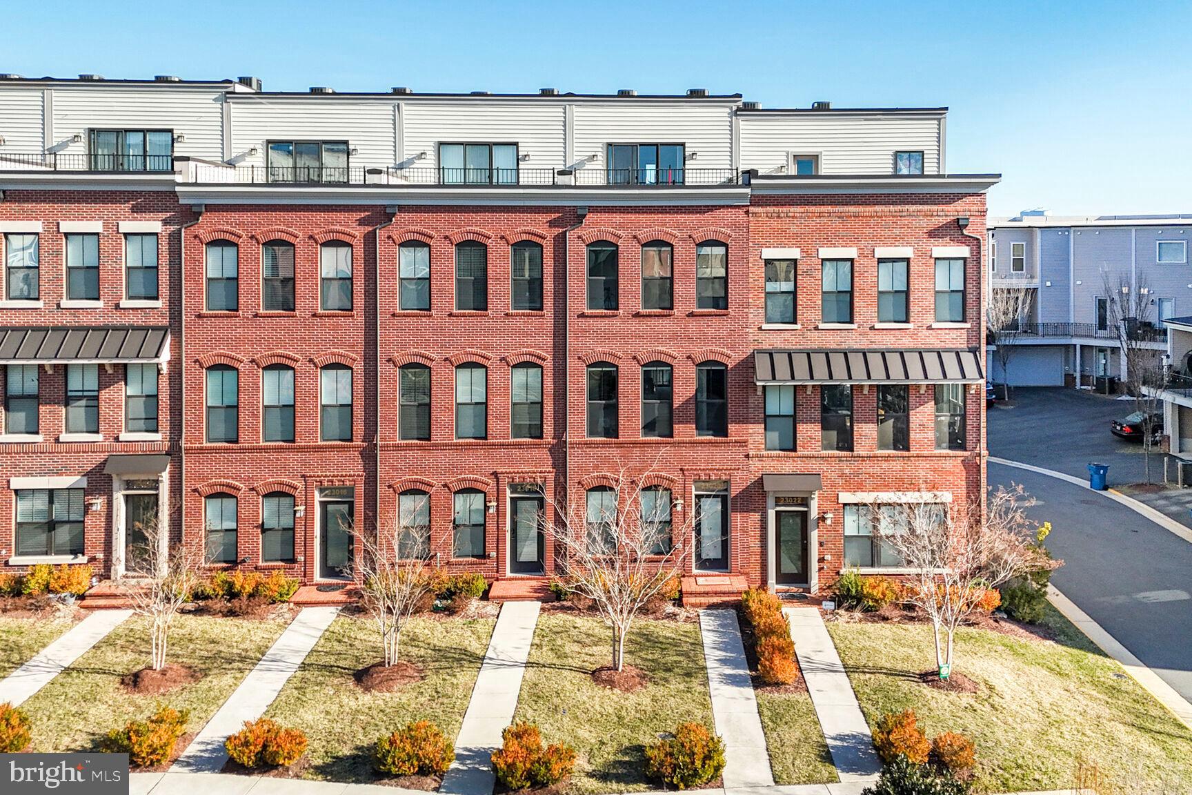 PRICE IMPROVEMENT!! Welcome to this beautifully maintained 4-level townhome which includes 3 bedrooms, 3.5 baths and two outdoor spaces in the vibrant Brambleton Town Center. This Fleetwood Model with Roof-Top Terrace was built by Knutson in 2018 and is located steps from all the shops and restaurants Brambleton Town Center has to offer. Step inside to the foyer where you have easy access to your two-car garage (with added storage space and EV charger plug-in) and an additional personal driveway parking spot. As you move to the second level an open concept main floor greets you and includes your living room, kitchen, dining room and a half bath. Recessed lighting guides you through this level and is a common feature throughout the home. Make lifetime memories by prepping your favorite dishes on the large kitchen island and enjoy an abundance of cabinet space so storage is never an issue. As you prepare your morning cup of coffee, on chilly days nestle next to the gas fireplace in the living room or on warmer days step outside to your personal balcony. 
Moving up the stairs to the third level is where you will find the primary and secondary bedrooms. Your primary bedroom features two walk-in closets, a bump-out for added space and an en-suite with a double vanity and step-in shower. In the hall you will have convenient access to the laundry where a new GE Profile Energy Start Combo Washer/Dryer was installed in 2025. This Combo Washer/Dryer unit allows for ample space to install shelving or cabinetry to store laundry goods and baskets (no more laundry baskets in the bedroom closet!). A south-facing second bedroom and full hall bath finish out this bedroom level. The fourth level includes a loft which can be utilized as an additional entertainment space or home office. Have your guests stay in the third bedroom, which is accompanied by a full bath and shower, or use it as a home office or workout space. Lastly, step outside onto your private rooftop terrace where you can design your outdoor escape to relax, grill or entertain. 
This south facing townhome allows for maximum energy efficiency yet has an abundance of natural light for an interior unit. Additional features include a Dual Zone EcoBee Smart Thermostat and a CuZn UC-200 Under Counter Water Filter (2024). Your monthly HOA dues include Fios Internet and Cable Television, common grounds and lawn maintenance, trash, and recycling services. As a resident of Brambleton Community Association you will be able to enjoy the outdoors with access to five swimming pools, eighteen parks (including Legacy Park, Morning Walk Park, and Creighton West Dog Park), play pickleball at Lake Birchwood, or take advantage of over 18 miles of trails! Brambleton is part of the Little Free Library program and has nine locations around town or visit the Brambleton Library at the Town Center. Venture over to Brambleton Town Center for a full annual calendar of events including Food Truck Fridays, Local Farmer’s Markets and the Brambleton Spring Fling or travel a short distance to The Barn at Brambleton for Live Music! Brambleton and this community is minutes to the metro and Dulles International Airport. Come visit and see why this townhome in Brambleton should be the next place you call home!